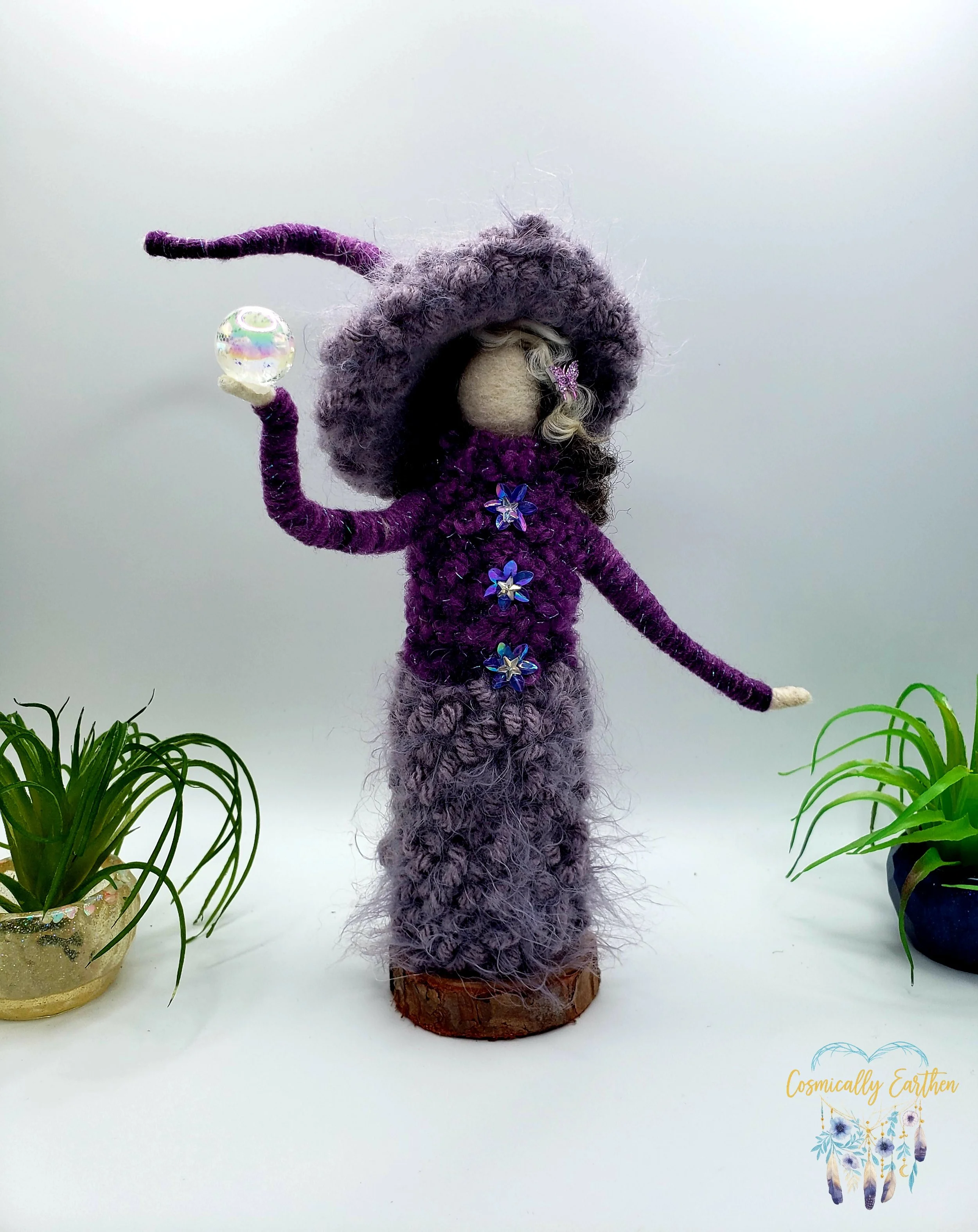 Close-up of needle felted art doll Velora in deep purple tones holding an orb, showing detailed wool textures and handcrafted fiber art features