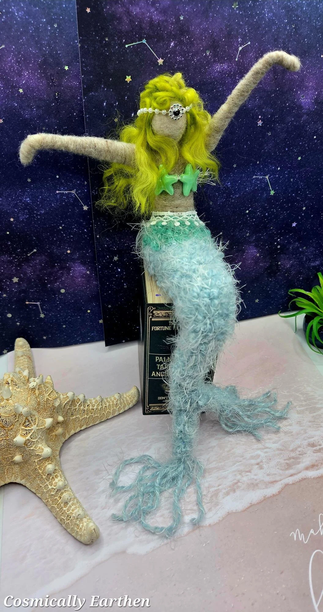 Handmade mermaid shelf sitter with long textured tail and raised arms, needle felted art doll with ocean-inspired colors