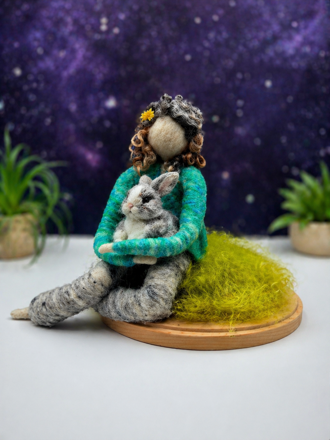 Handmade needle-felted companion figure holding a small rabbit, seated on a grassy base, created as a custom pet keepsake.