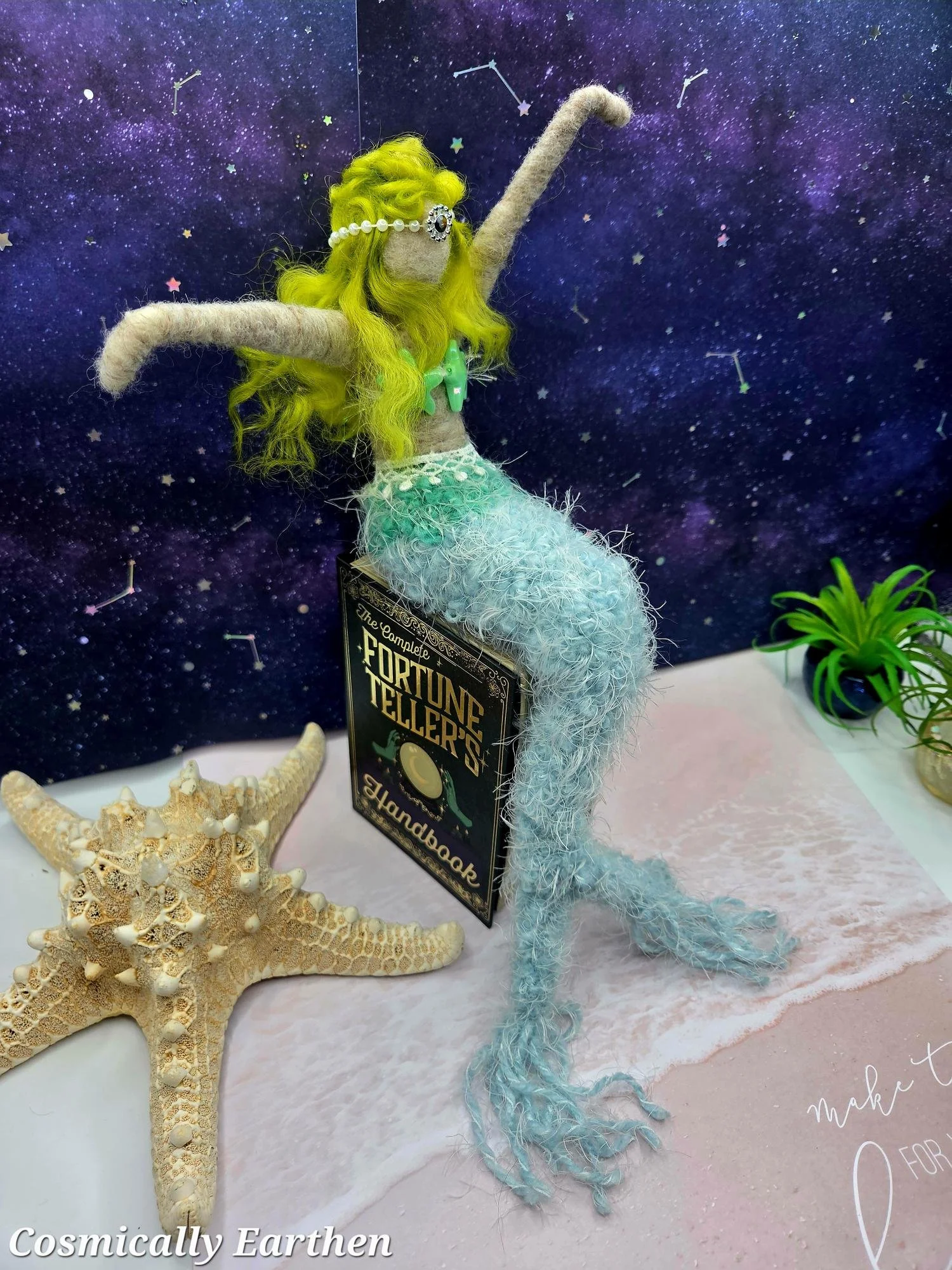 Handmade mermaid shelf sitter with long textured tail and raised arms, needle felted art doll with ocean-inspired colors