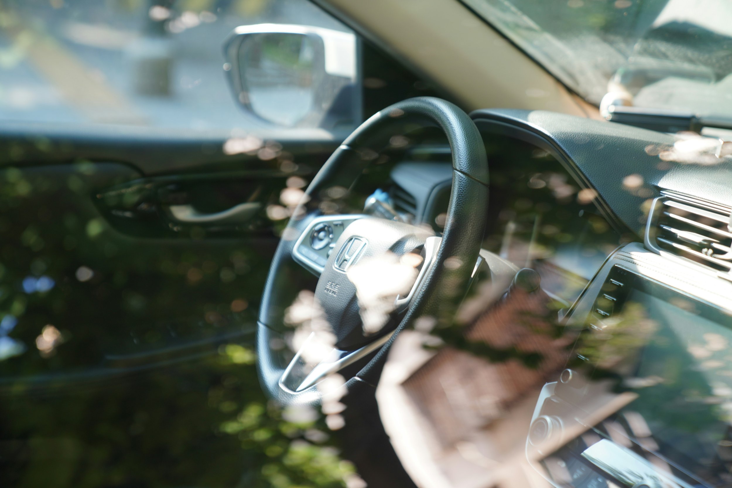 Car interior with soft natural light and reflections, representing a calm and balanced personal space within a vehicle
