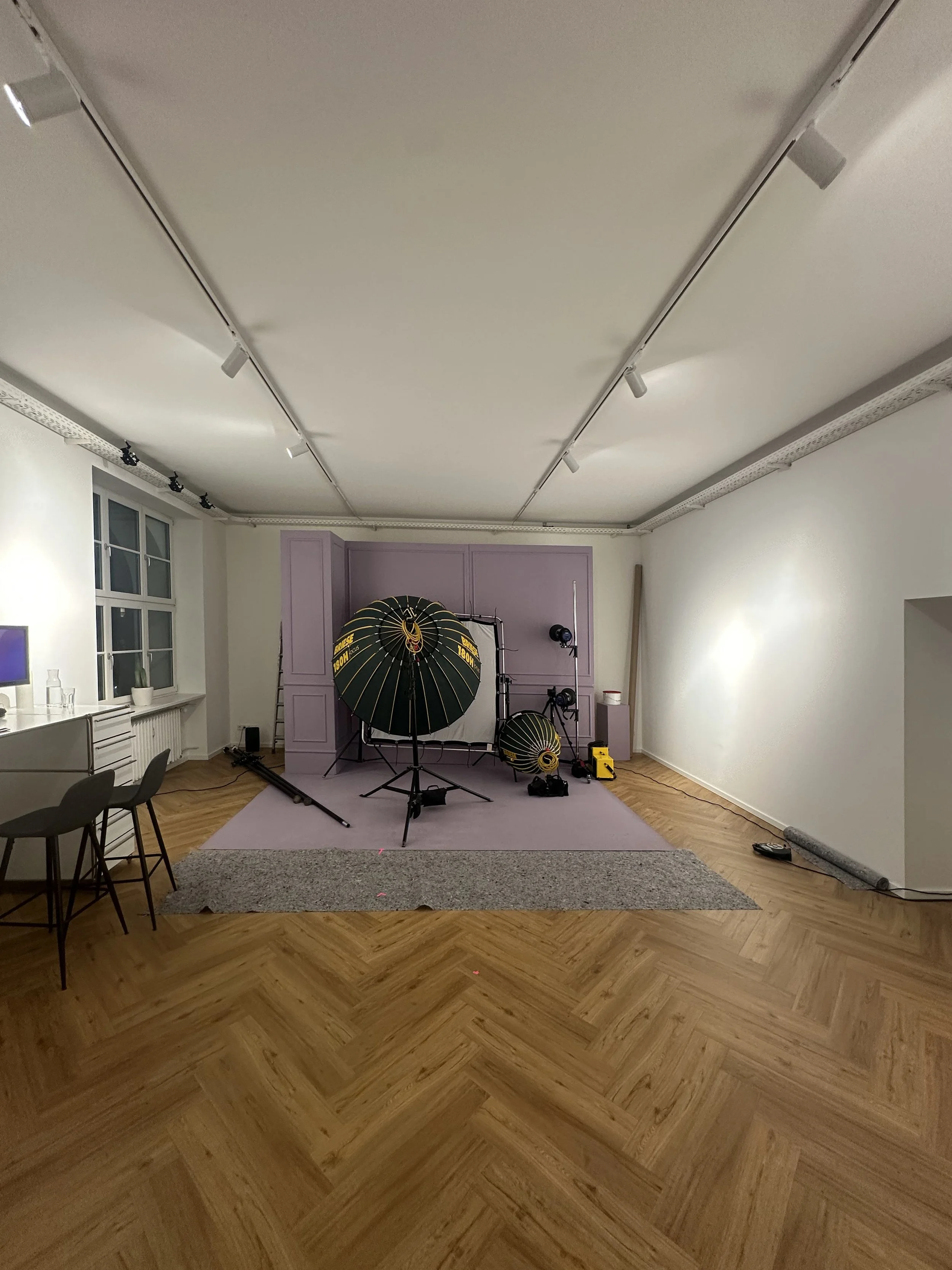 Fotostudio mit Pink hintergrund und professioneller Beleuchtungsausrüstung, incl. Reflektor, Scheinwerfer und Studioblitz.