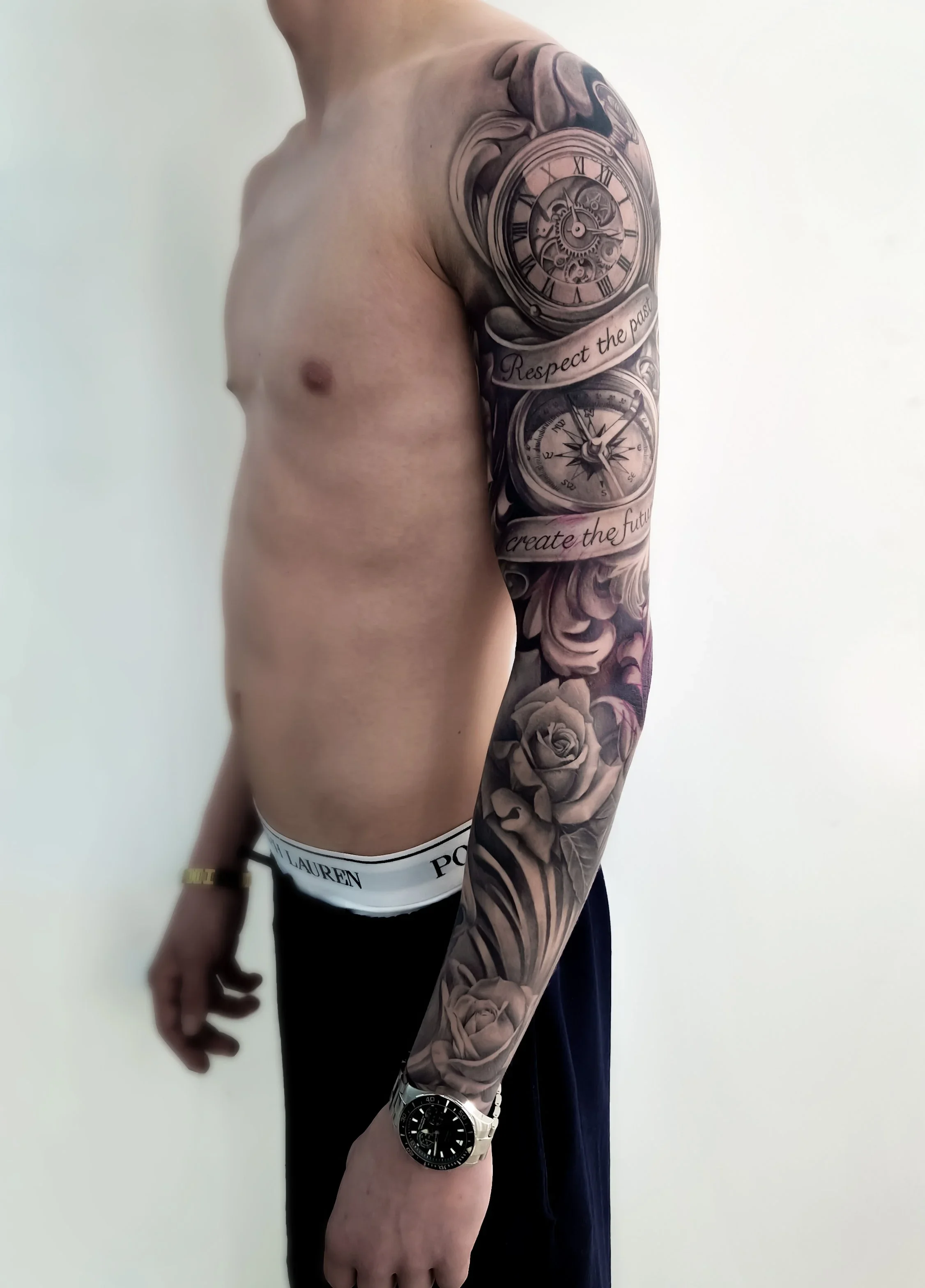 Flot full sleeve tatovering med filigree, kompas og ure – detaljeret black and grey realism tattoo udført hos Lind Studio i Randers