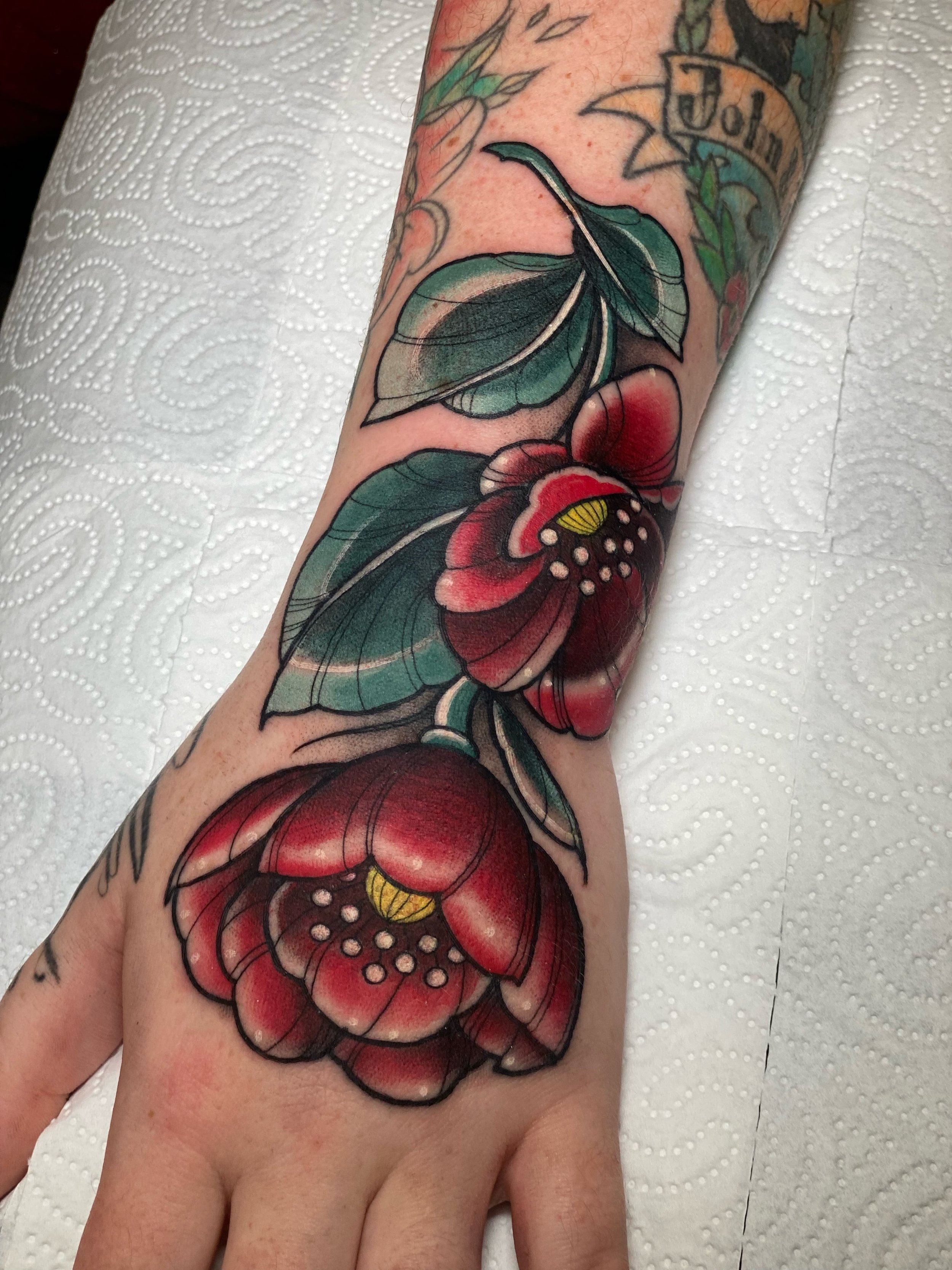 “Farverig blomster tattoo på armen med dekorative detaljer lavet af tatovør Bruno Mazallo