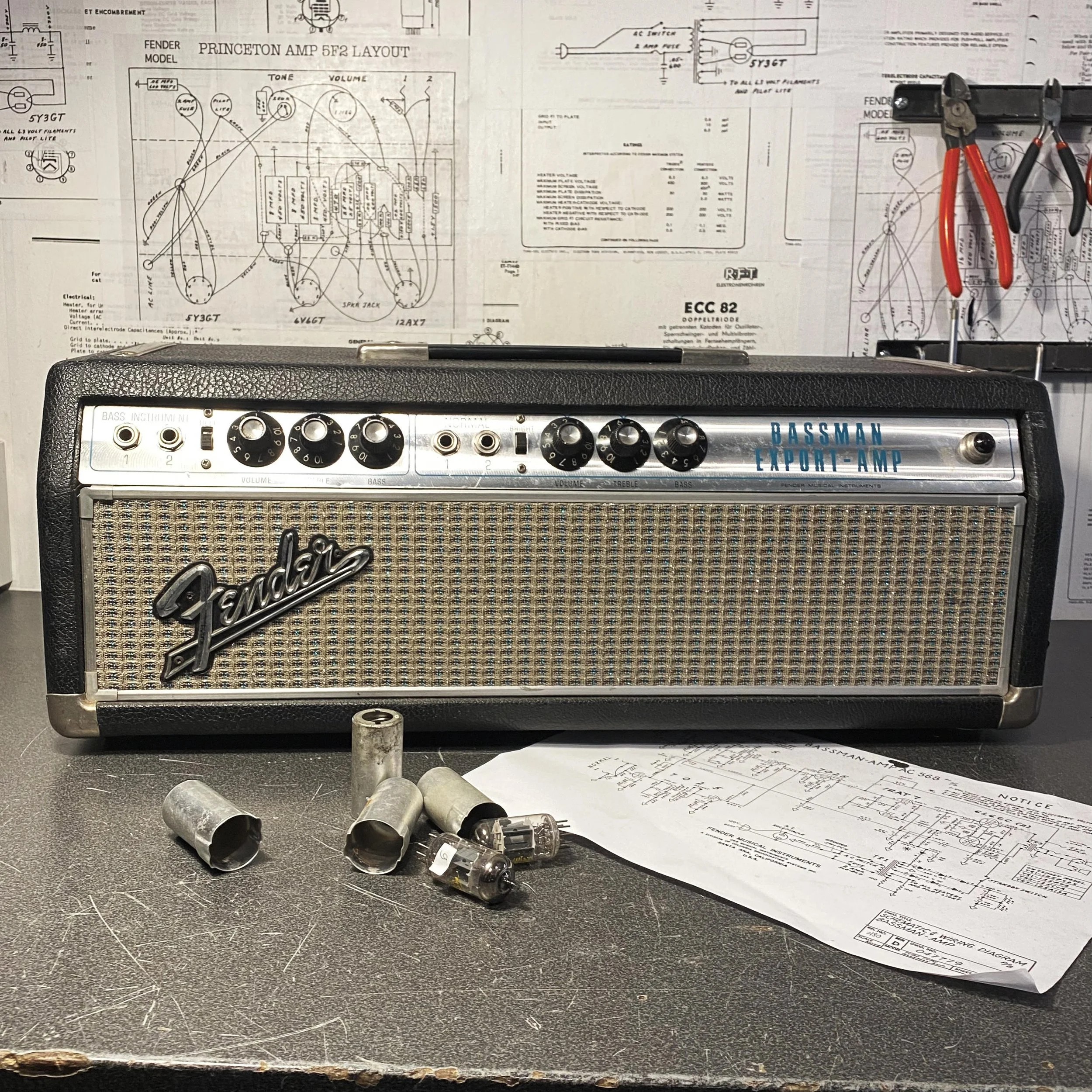 Réparation d’un Fender Bassman avec remplacement de lampes, schéma technique visible devant l’ampli