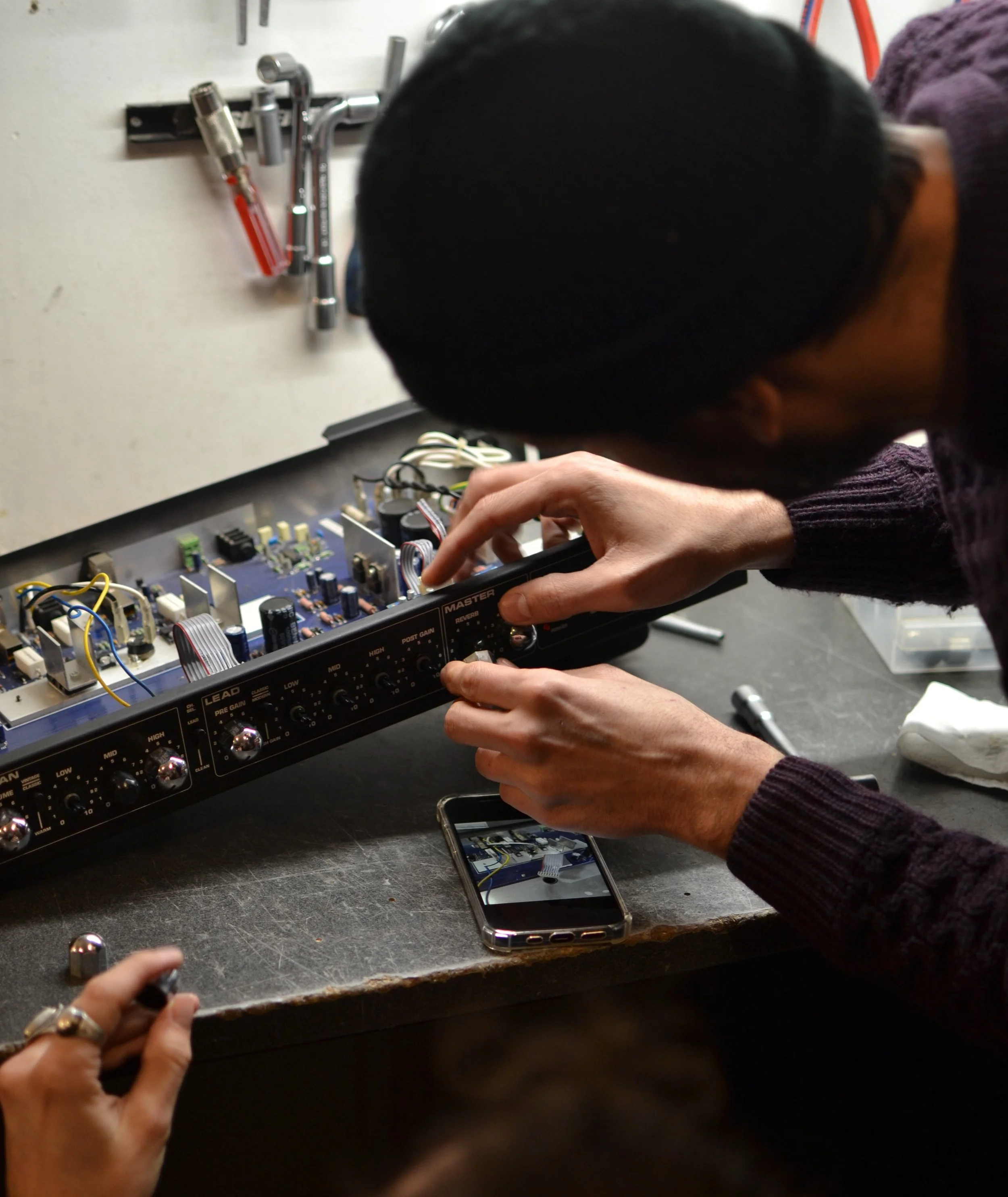 Formateur et élève remontant un amplificateur après réparation lors d’une formation
