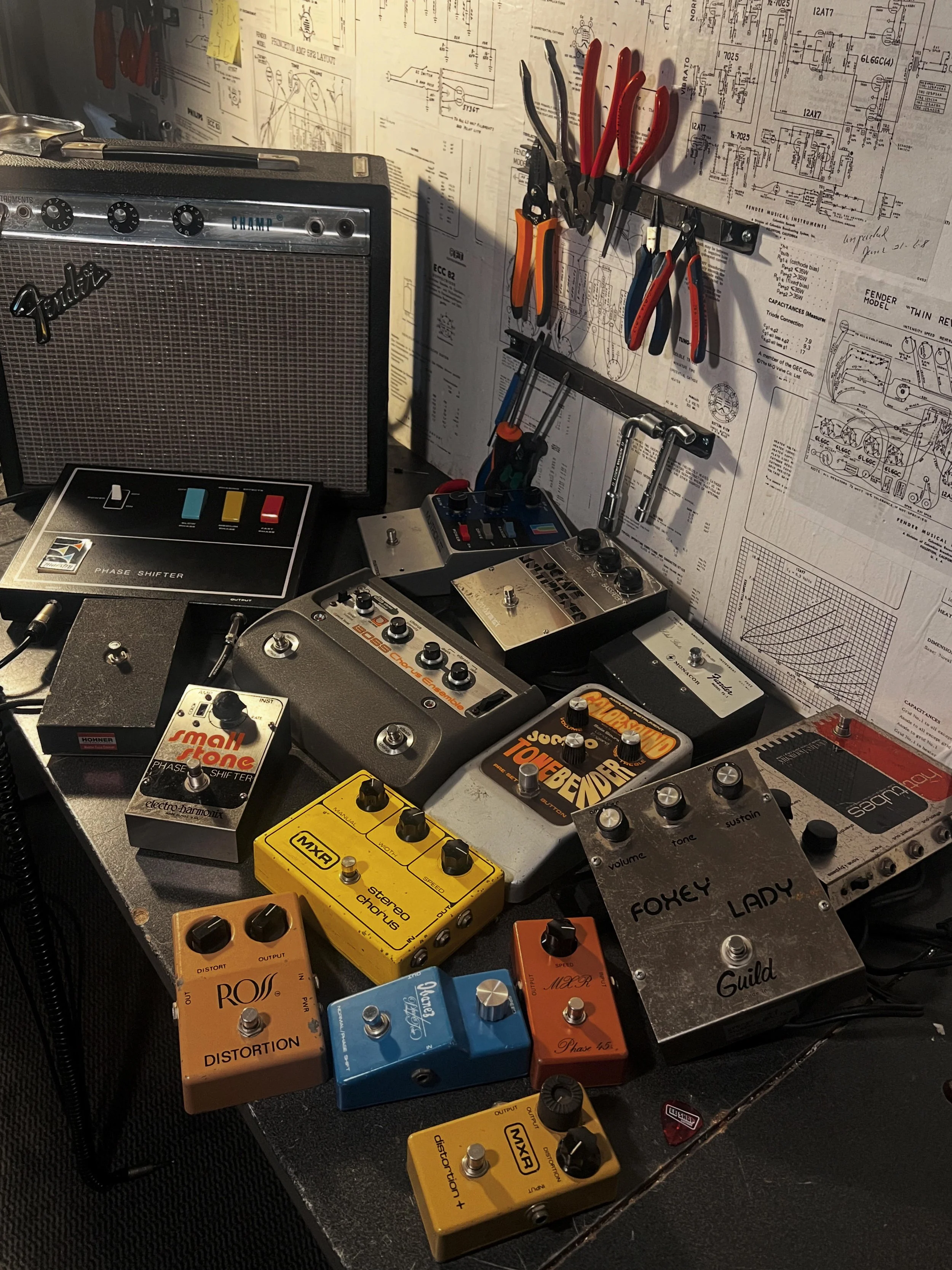 Pédales d’effets vintage de différentes marques sur l’établi de l’atelier