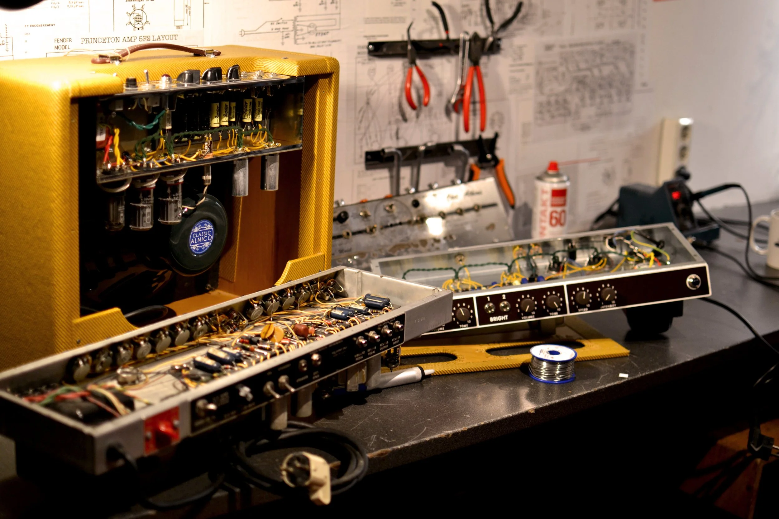 Poste de travail lors d’une formation, amplis à lampes ouverts et fer à souder en utilisation