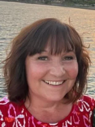 Nighttime landscape with star-filled sky, bright planet, mountain silhouette, and calm water reflecting moonlight.