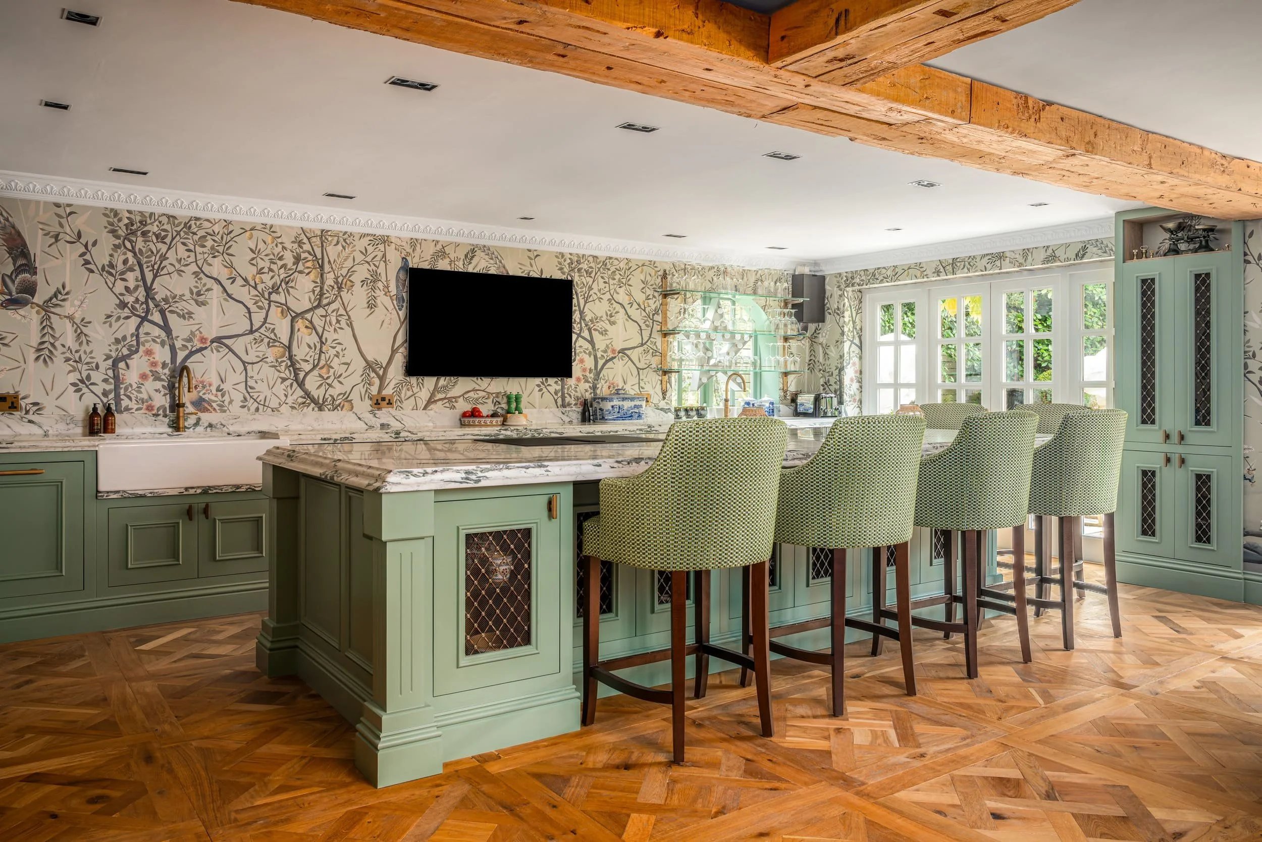 A countryside kitchen located in Oxfordshire. Beautiful green colour scheme, with eye catching wallpaper. Designed by Amplyfy Group.