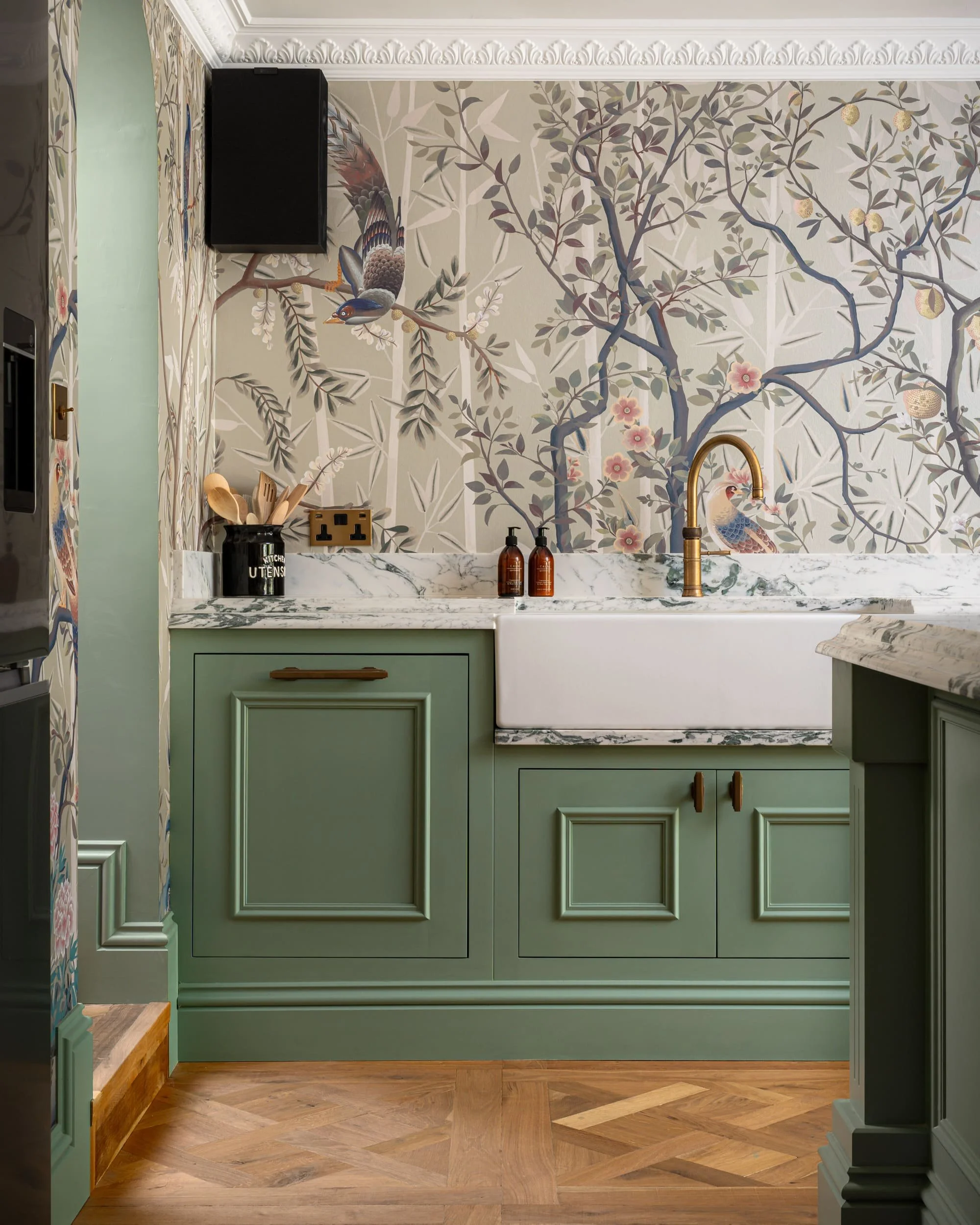 A countryside kitchen located in Oxfordshire. Beautiful green colour scheme, with eye catching wallpaper. Designed by Amplyfy Group.