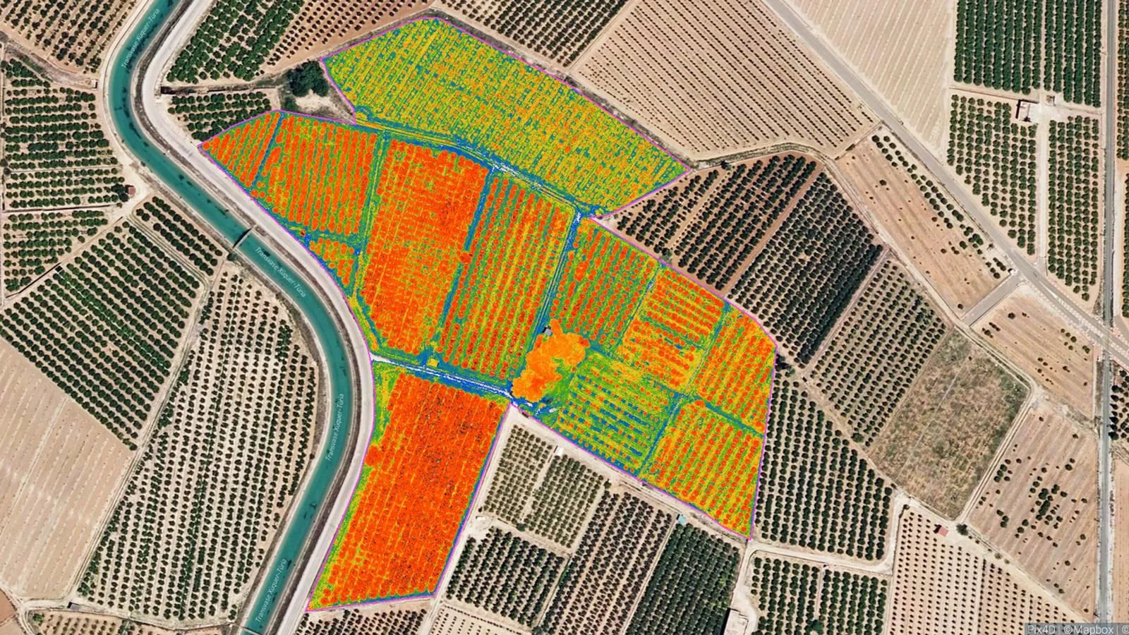 Aerial view of agricultural fields, with some crops highlighted in color-coded thermal or health map, adjacent to a winding river and surrounded by various farm plots and orchards.