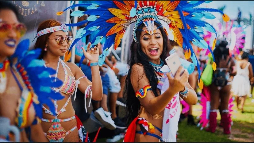 Group of musicians playing trumpets and a saxophone on a city street at night.