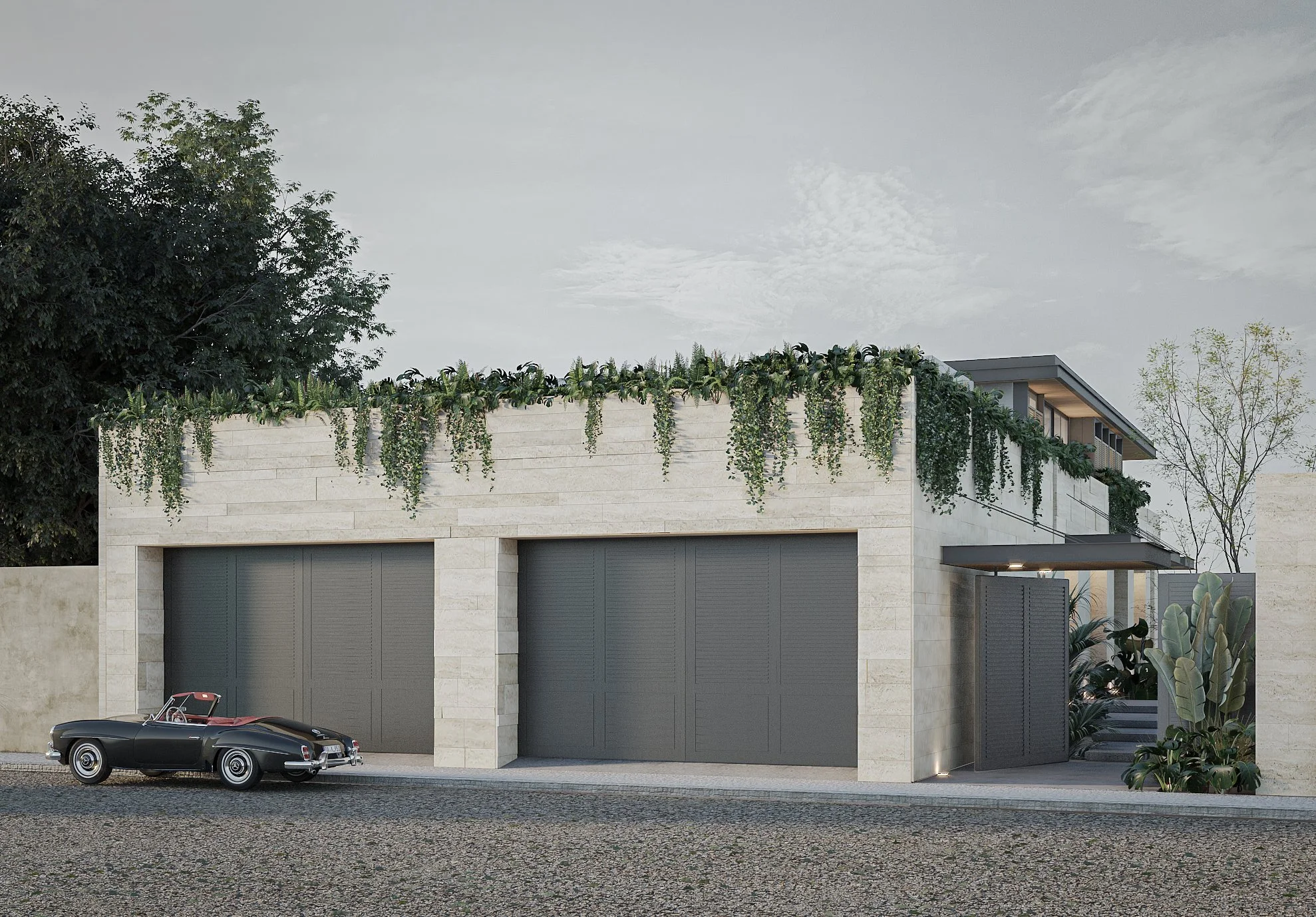 Vista de una casa moderna con paredes de piedra clara, un garaje con puertas grises y vegetación en la azotea y a un lado, con un coche clásico negro estacionado en la calle de pavimento de piedra.