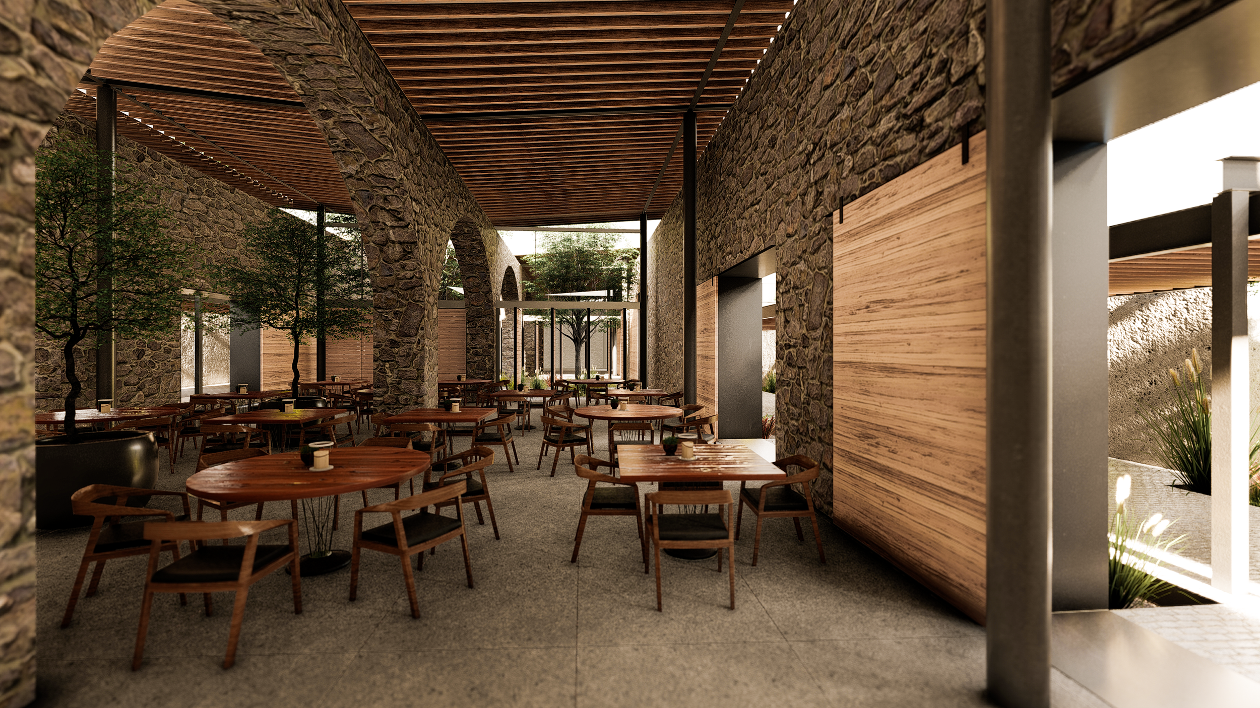 Interior de un restaurante con paredes de piedra, suelo de concreto y techo de madera, con mesas redondas de madera y sillas modernas, y algunos árboles decorativos en el ambiente