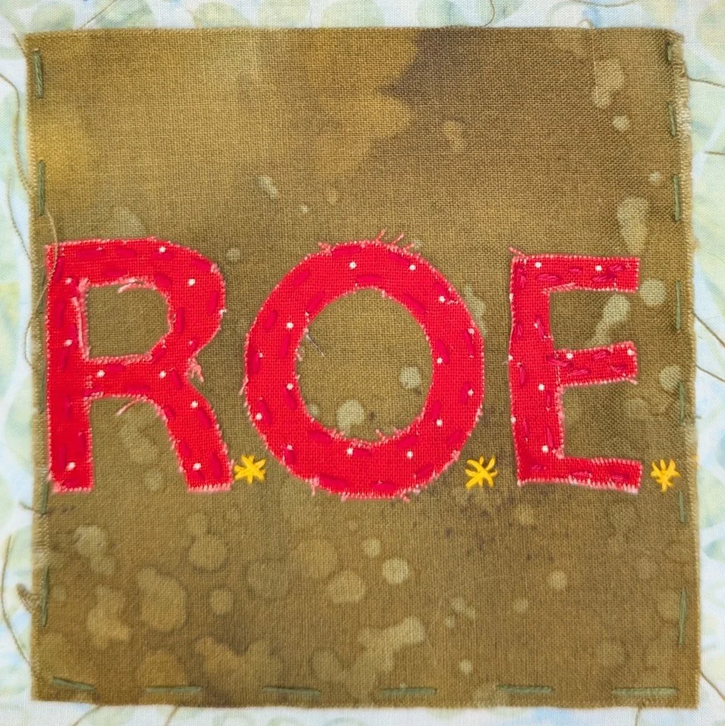 The letters R. O. E. in red fabric on olive green background
