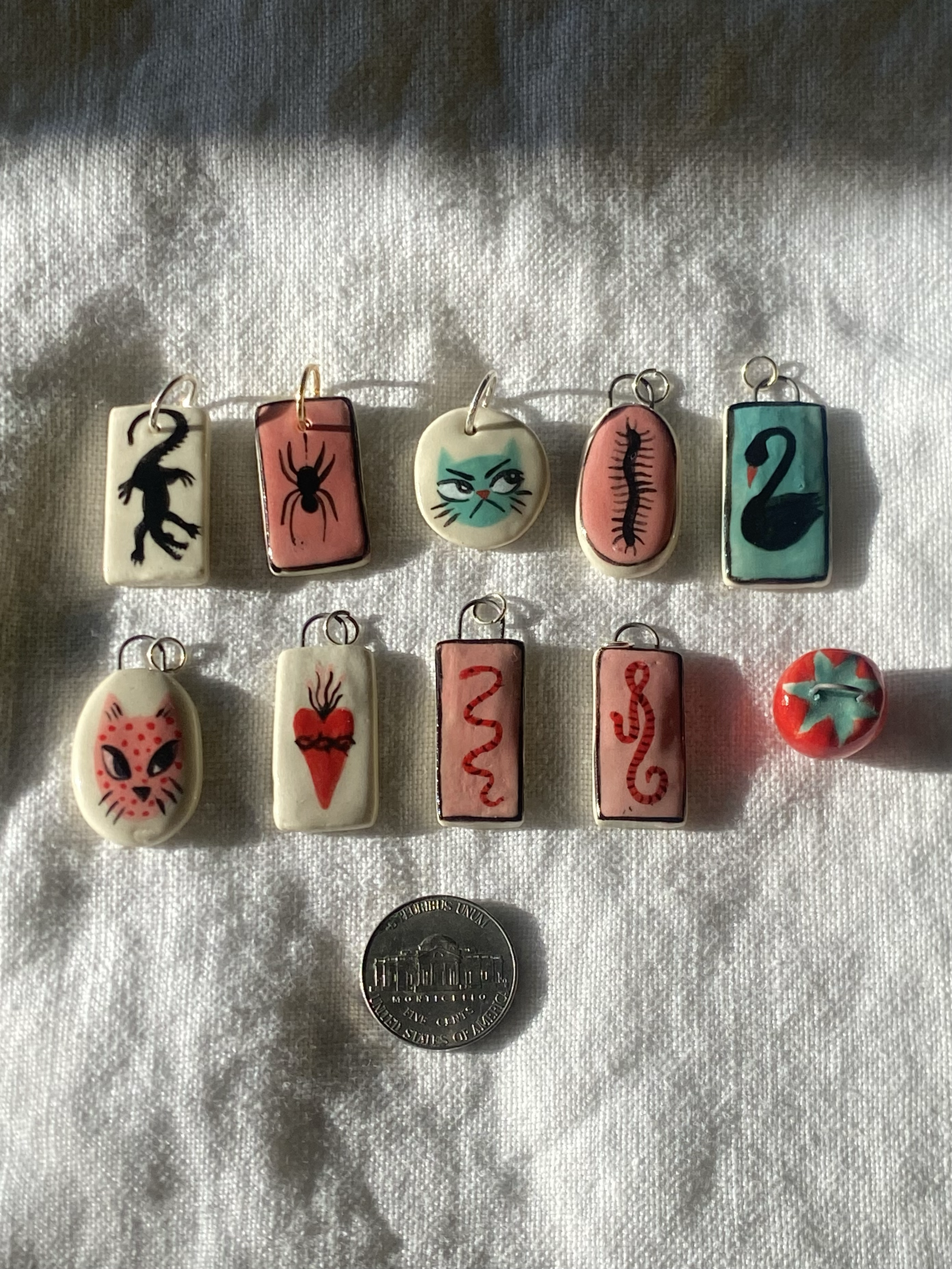 Pendants, 2025. 
Stoneware clay, underglaze, clear glaze.