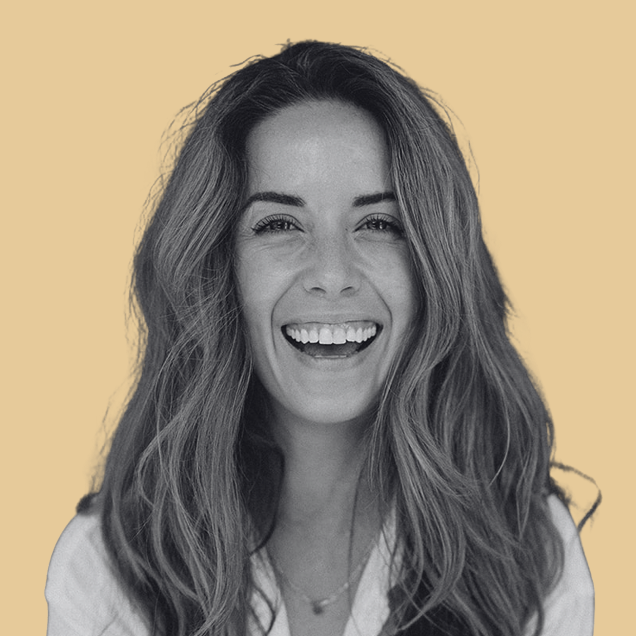 smiling woman with waving hair wearing a white collared shirt