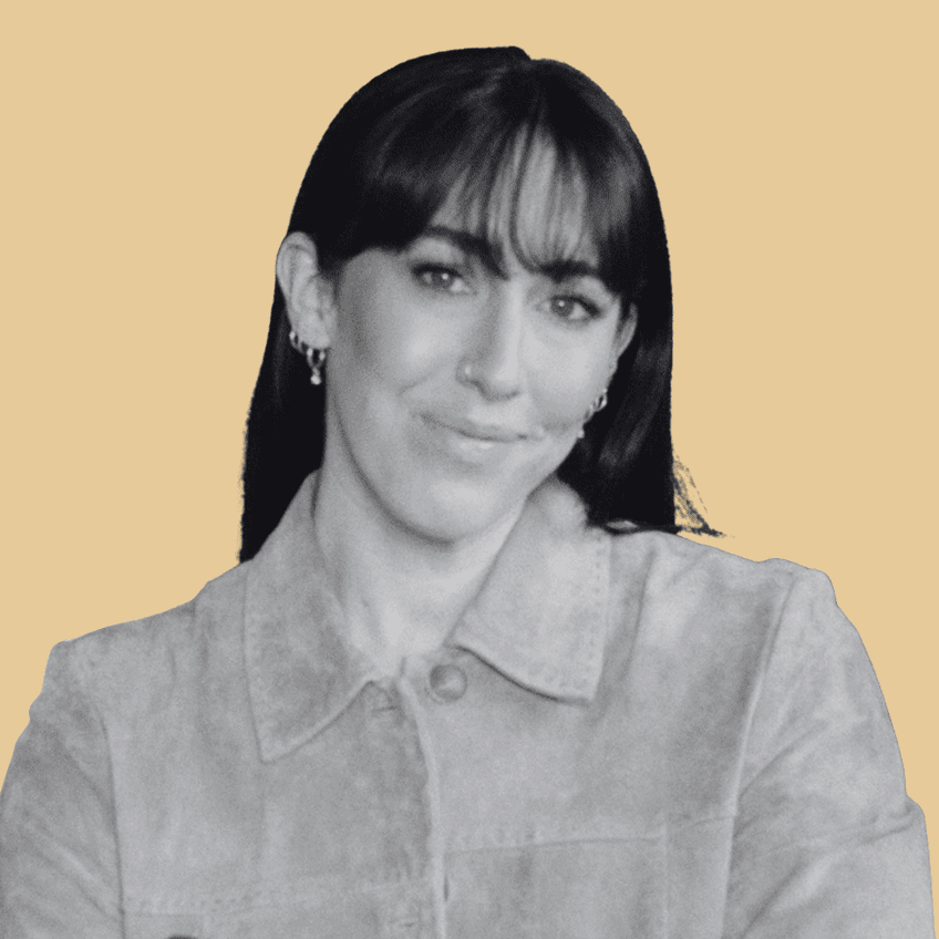 portrait of a woman with dark straight hair and bangs smiling at the camera with a yellow background