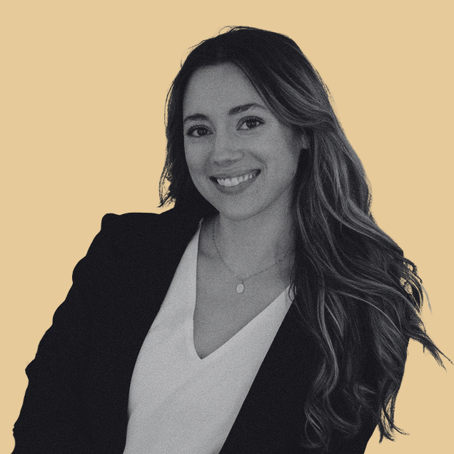 smiling woman with long wavy hair wearing black blazer and white shirt