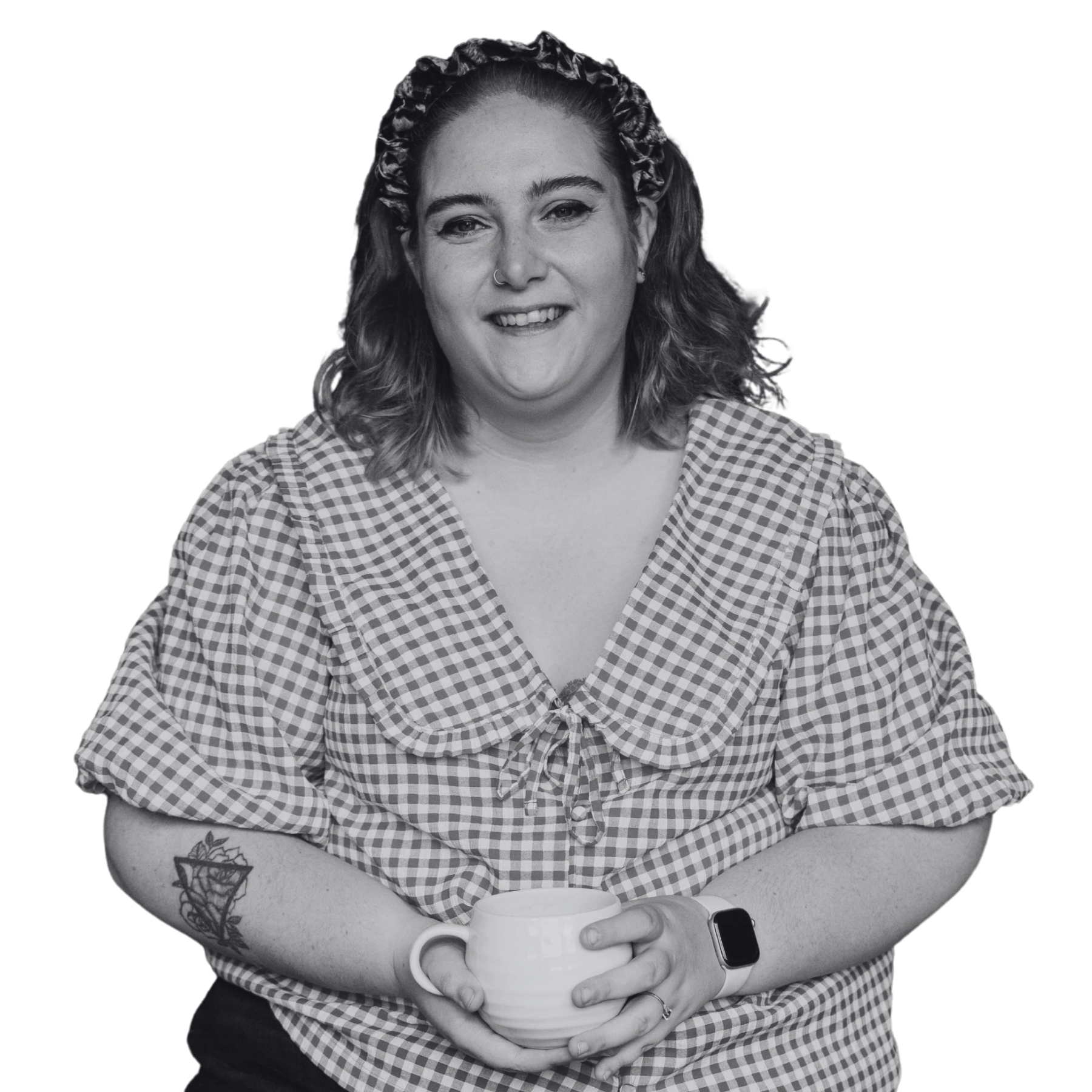 smiling woman wearing checked shirt and headband holding a cup
