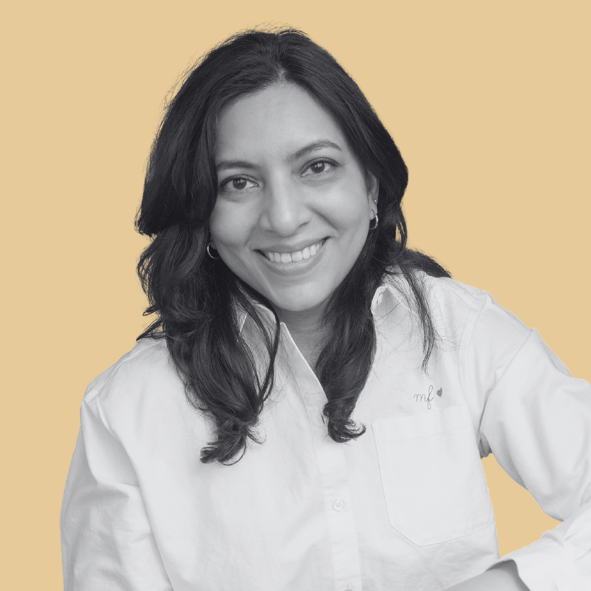 smiling woman wearing a white button down shirt on a yellow backgroud