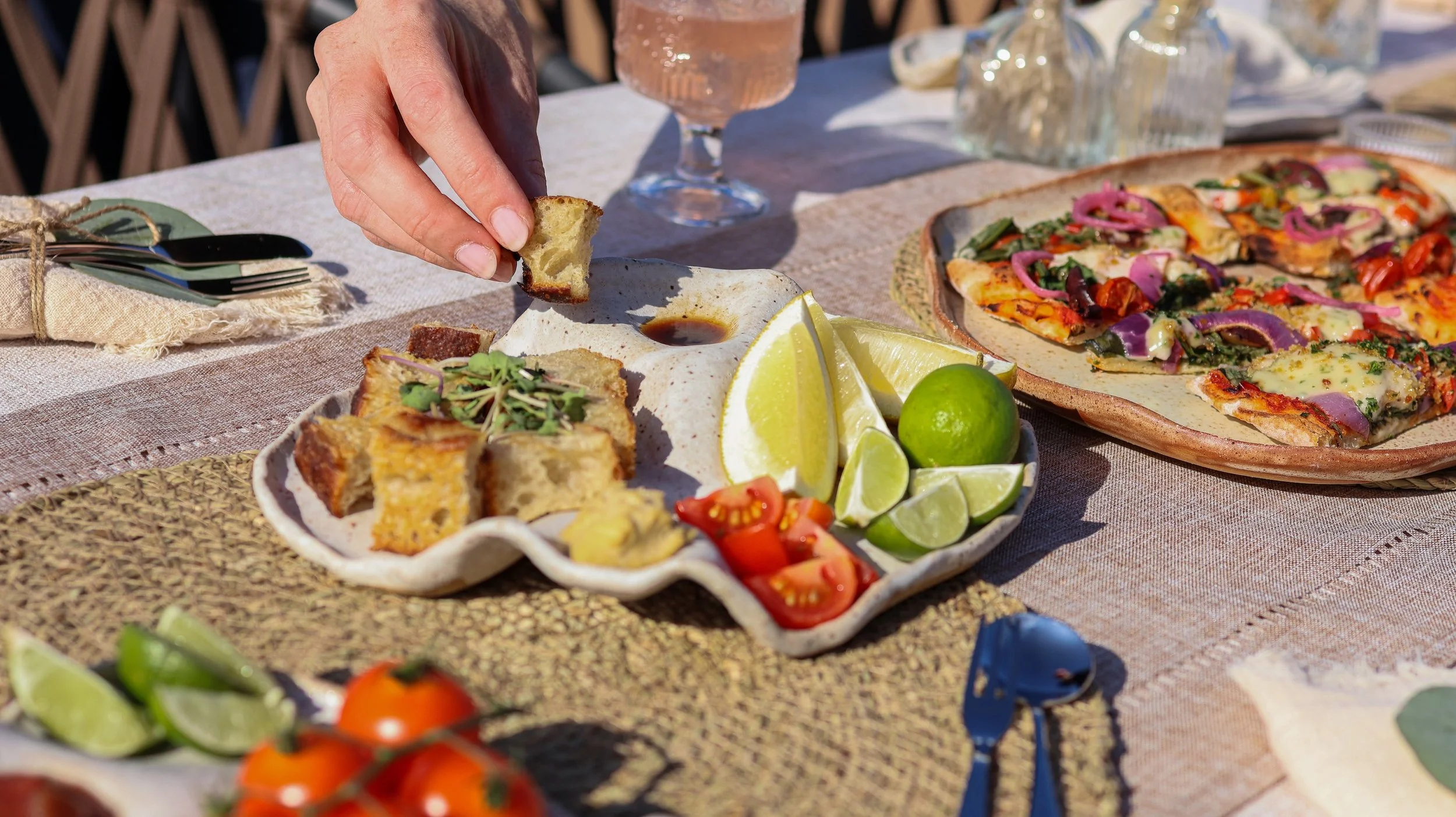 textured ceramic bowl with speckled glaze with bowl of spaghetti pasta on a beige table cloth