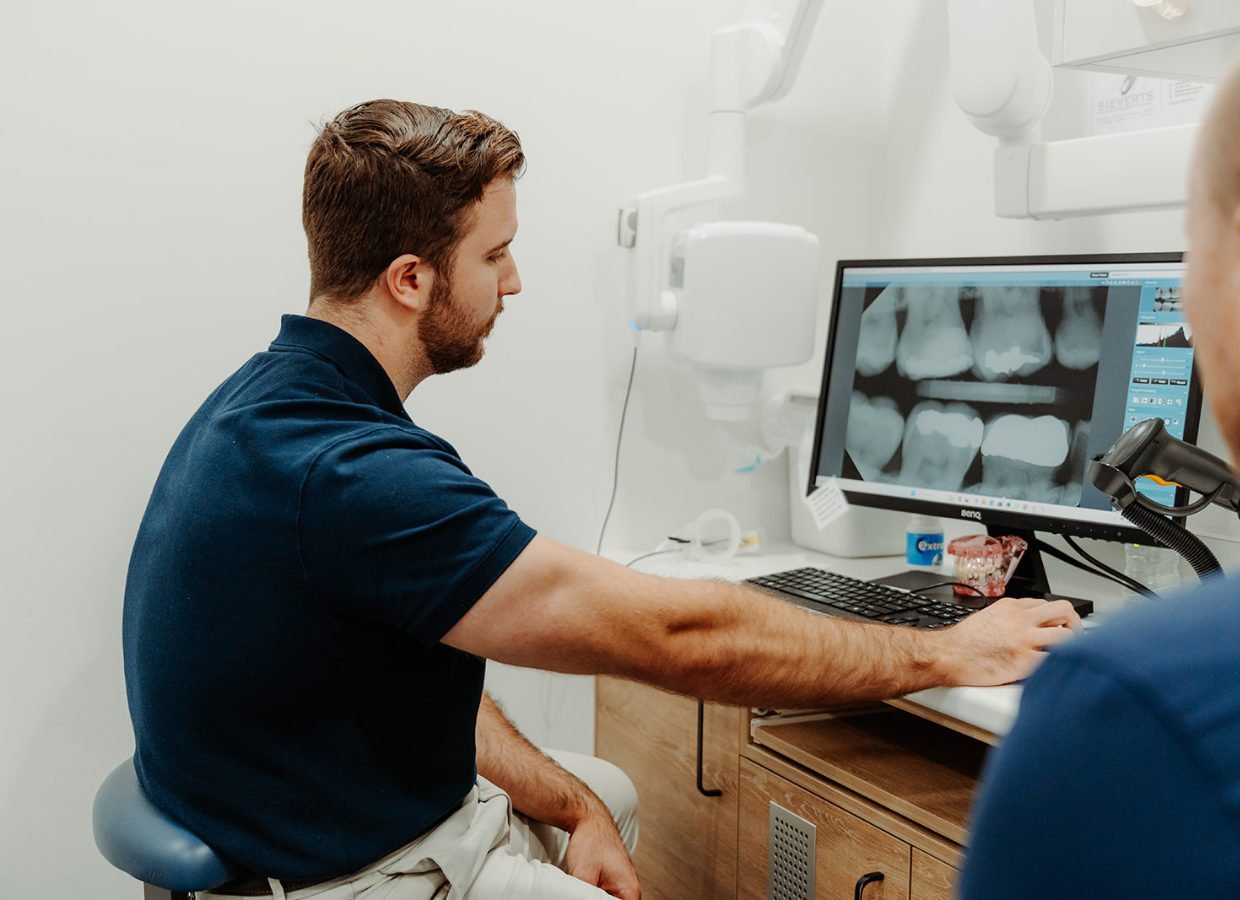 Our dentist and a patient examining dental X-rays on a computer at Wurtulla dental office.