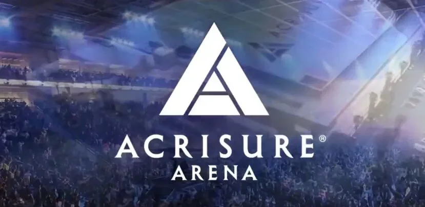 Logo of Acrisure Arena over a concert or event stage filled with crowd, illuminated with blue and purple lighting.