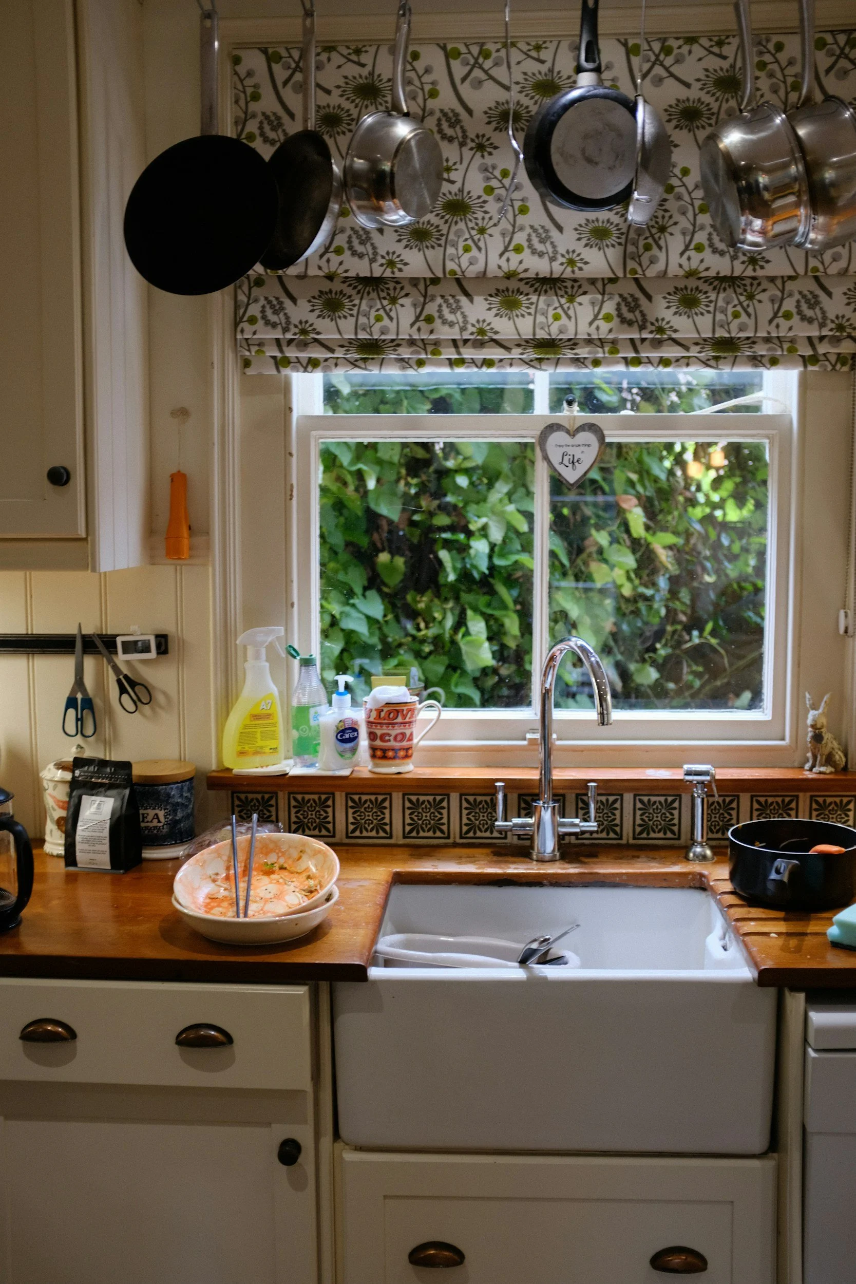 Kitchen sink with dishes in natural light near a window, representing everyday challenges with eating and routines for people with ADHD
