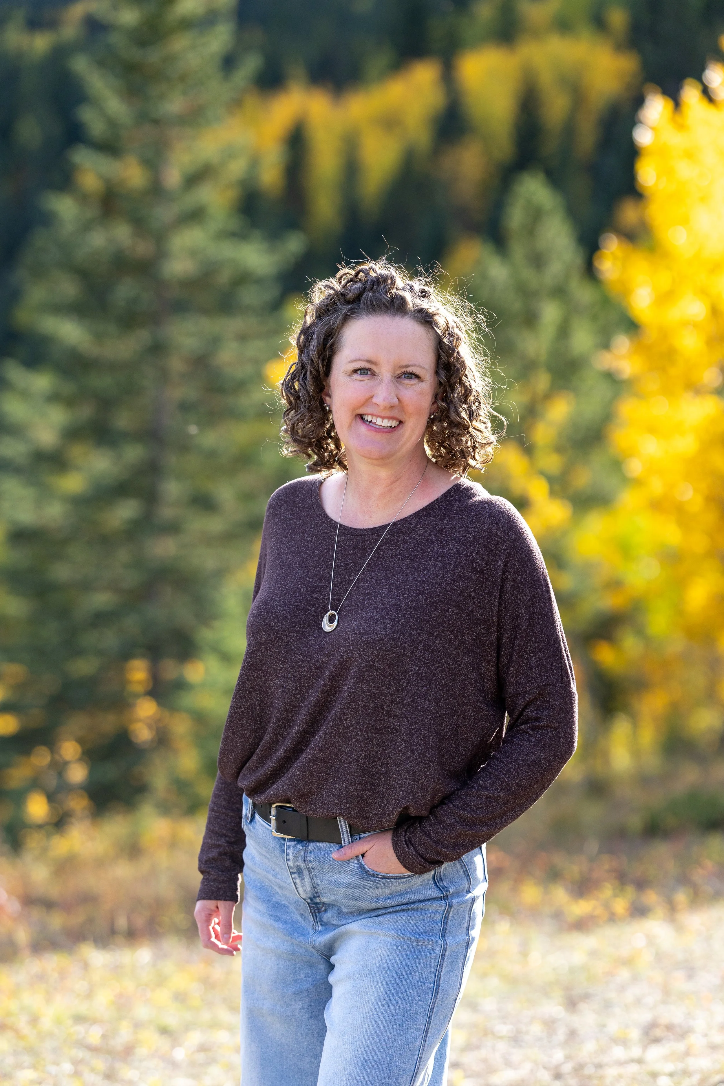 Portrait of Andrea Kroeker in front of a softly blurred backdrop of trees