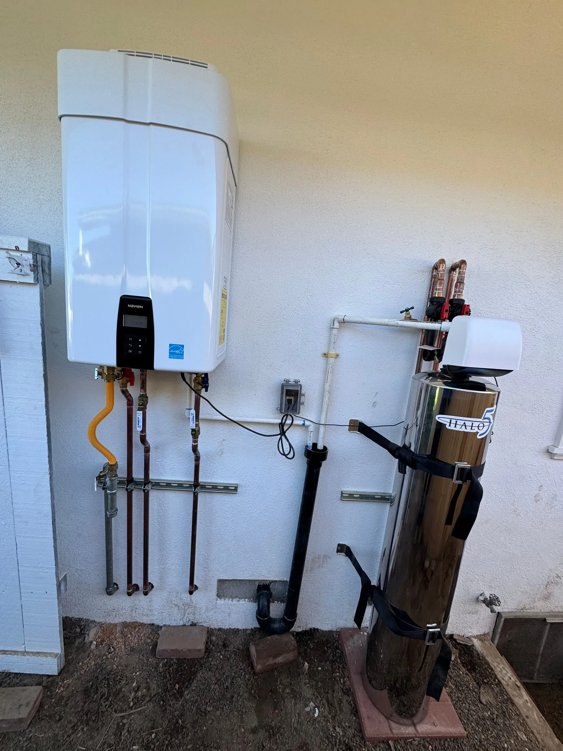 Tankless water heater installation with plumbing connections