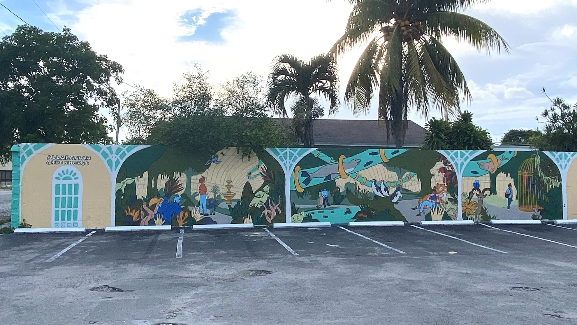 Colorful wall mural of various animals such as penguins, birds, fish and people surrounded by plants, mountains and water