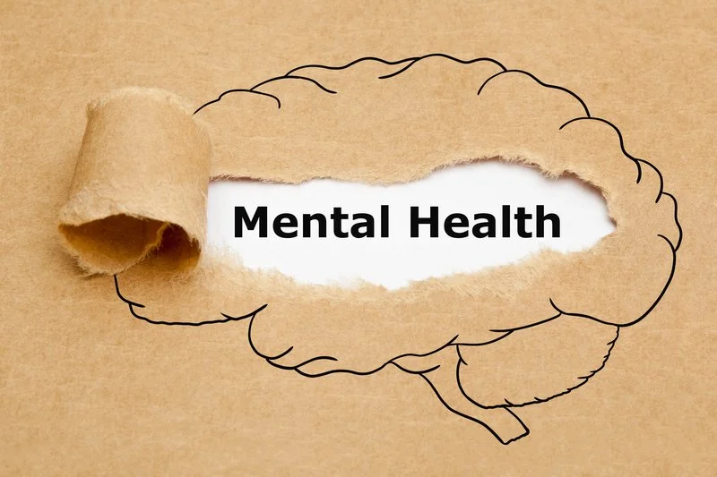 drawing of brain on brown paper with center torn to reveal the words mental health