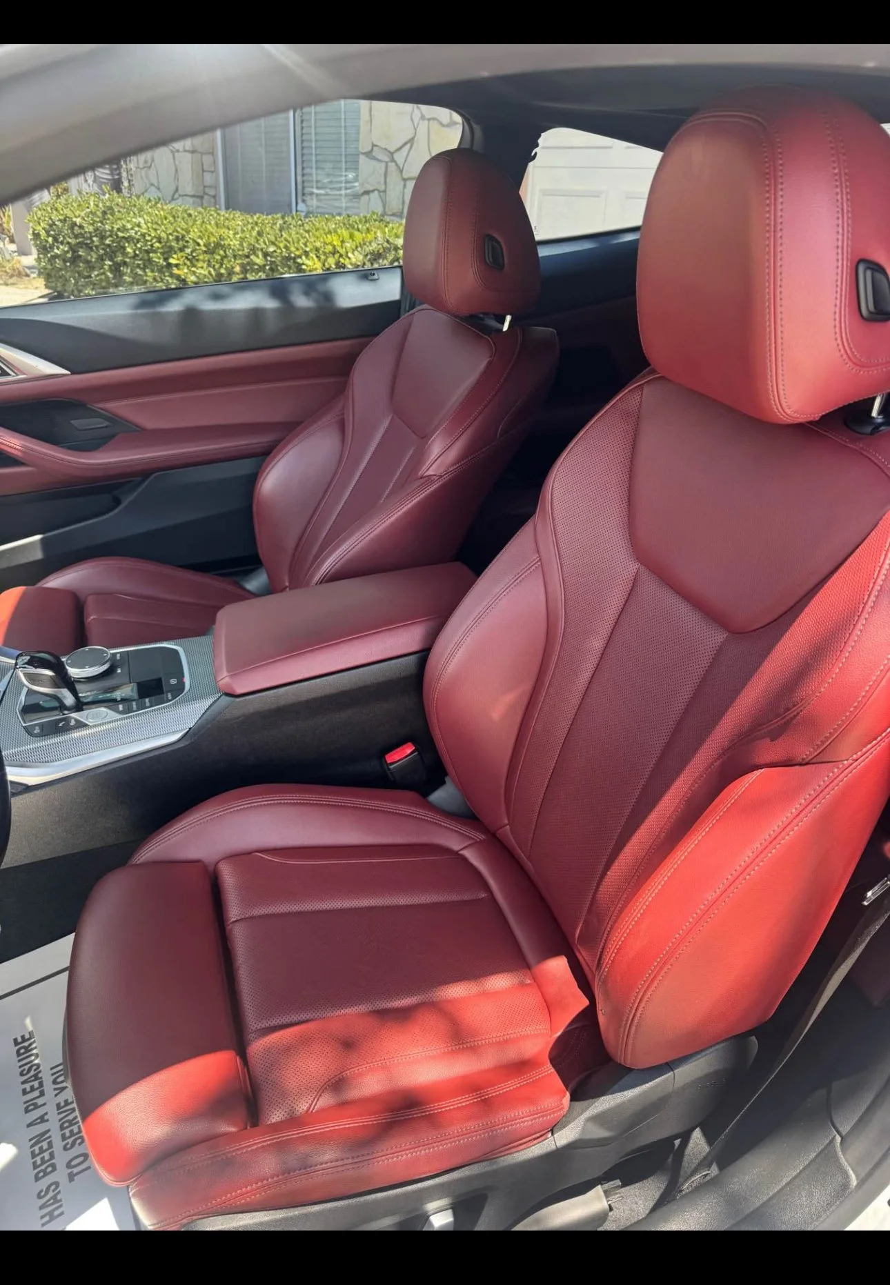 Interior of a car showing red leather seats and a center console with controls and a gear shift.