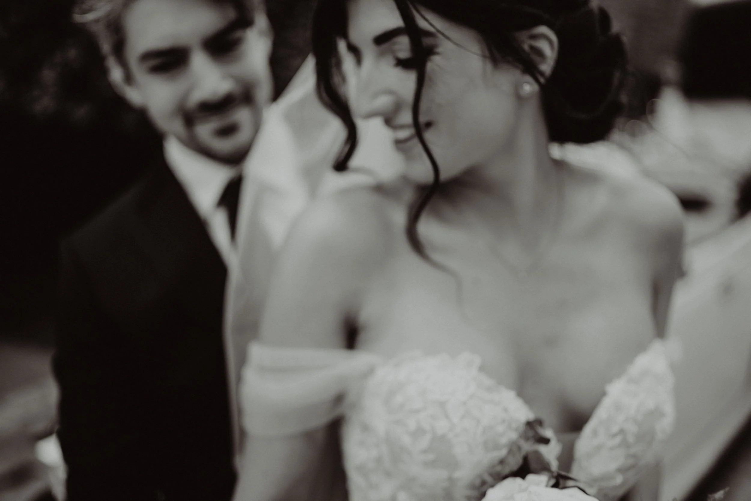 Una coppia di sposi sorride e si guarda affettuosamente durante il loro matrimonio.