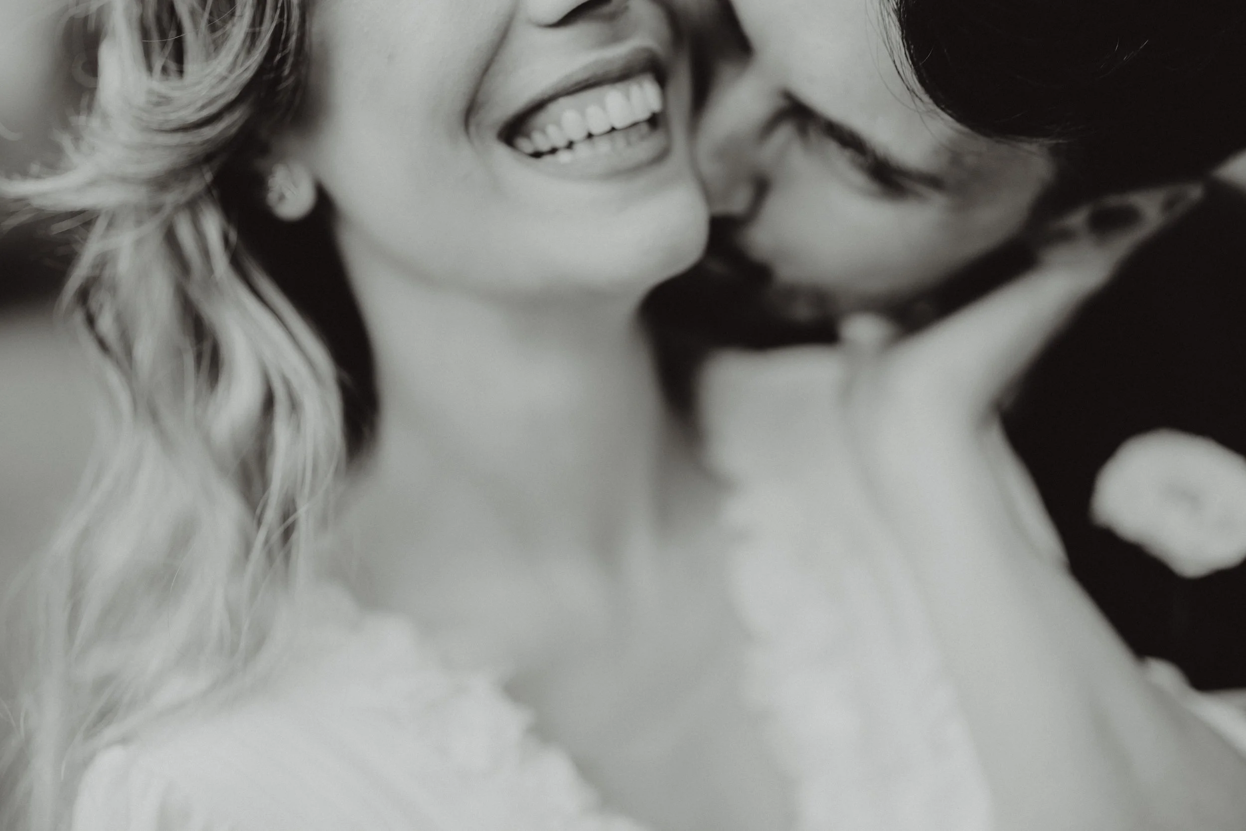 Una coppia di persone che si baciano e si sorridono, in bianco e nero.