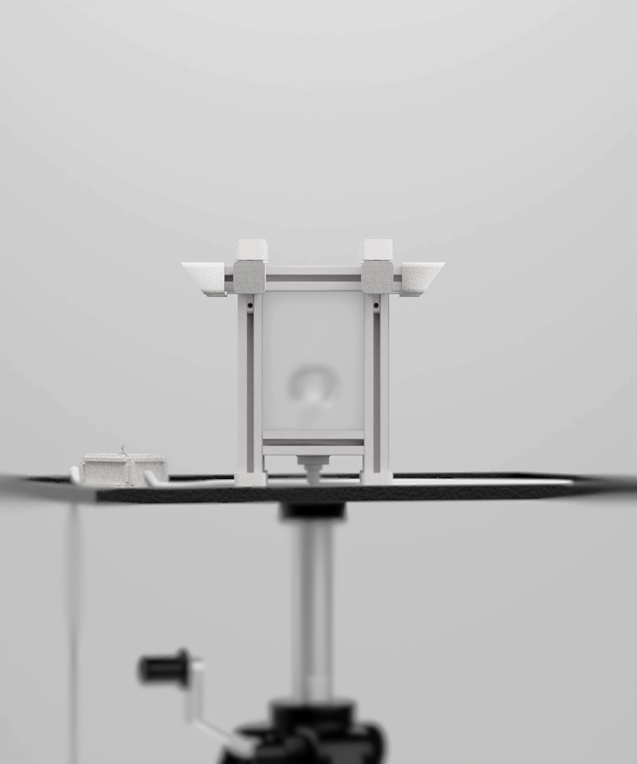 A close-up of a mechanical device with white and black components, mounted on a black surface against a plain white background.