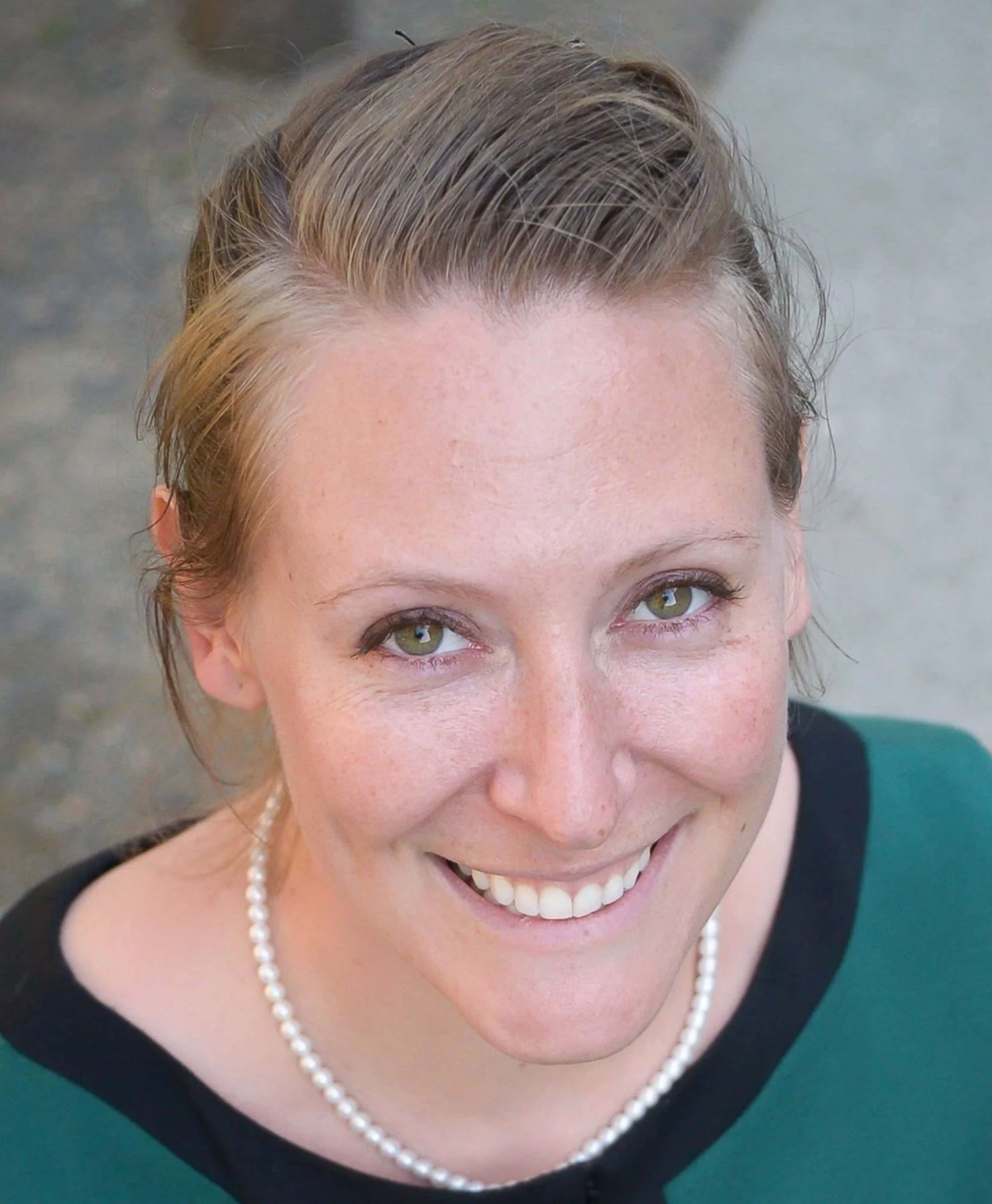 Photo of Ashley N. Franzen, MFA smiling, wearing a green dress.