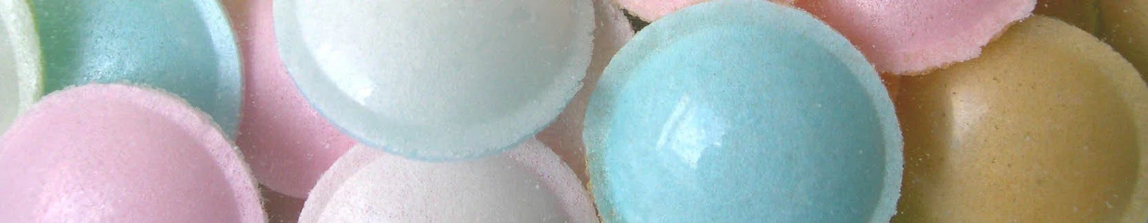 Gros plan de plusieurs bonbons colorés, principalement en pastel, avec une surface sucree et un aspect arrondi.