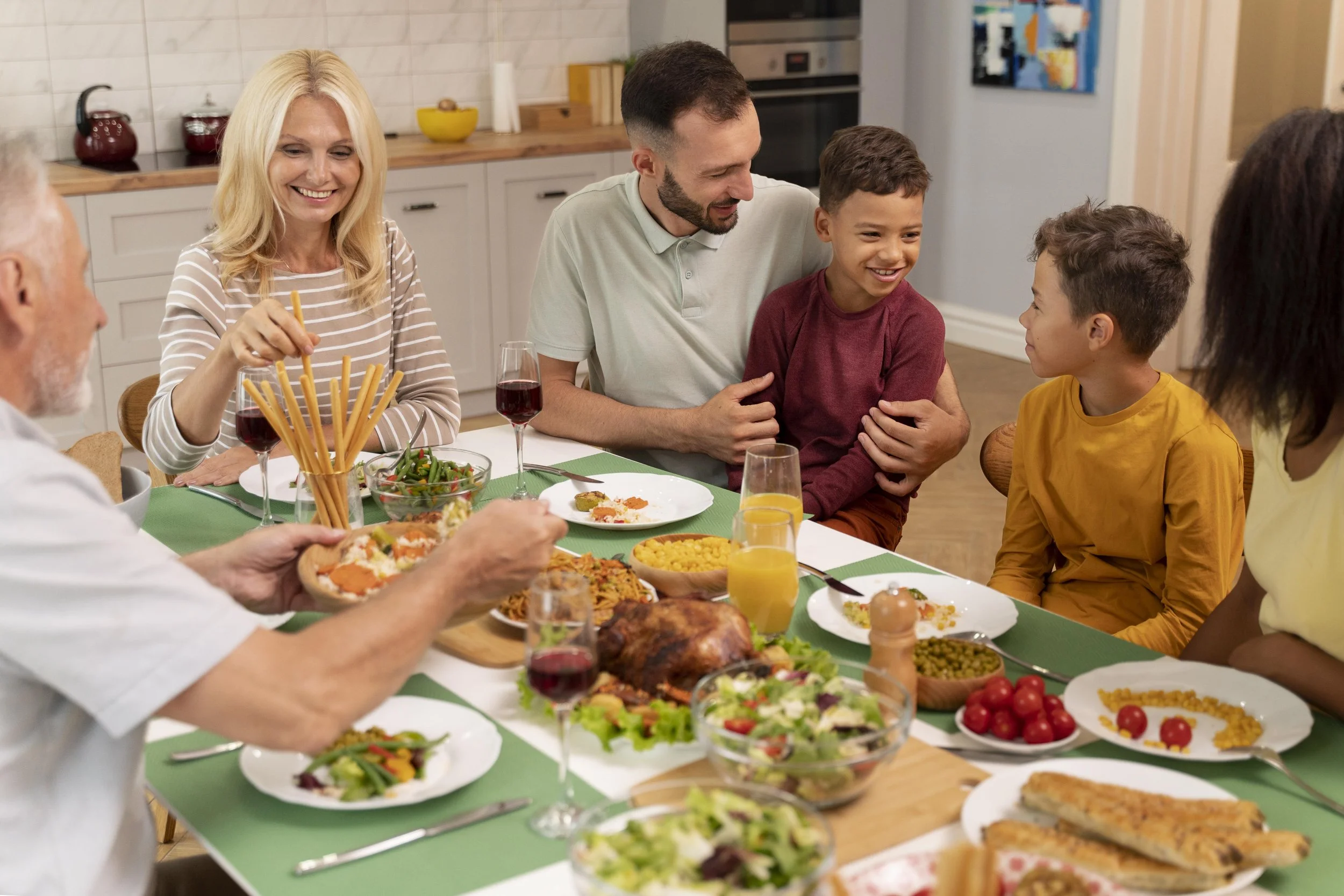 Une famille réunie autour d'une table pour un repas, souriant et partageant un moment convivial
