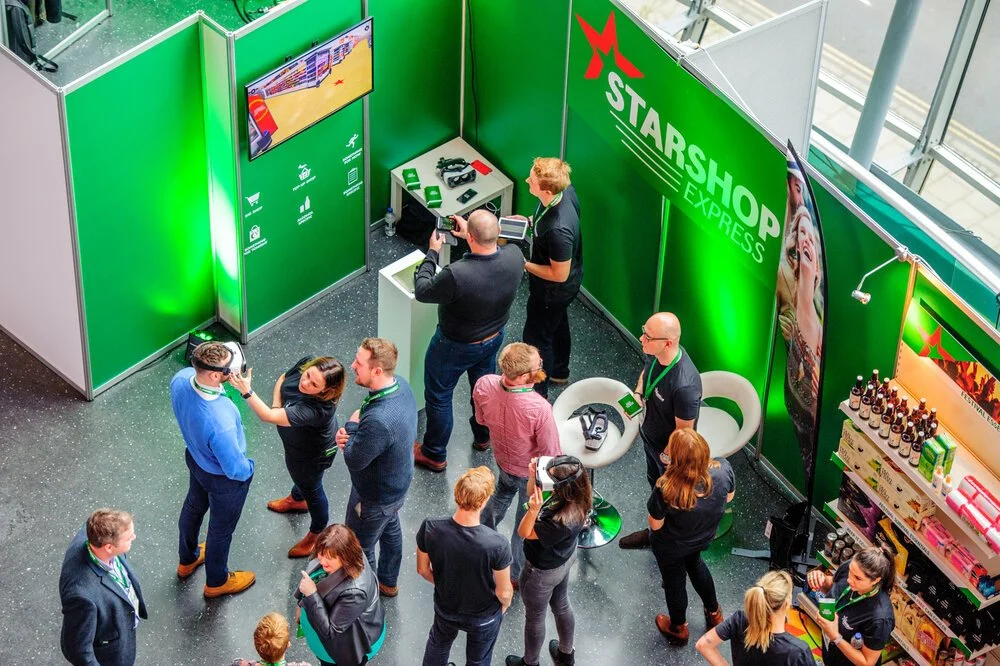 Overhead trade show photography showing delegates taking part in an interactive exhibition stand activation.