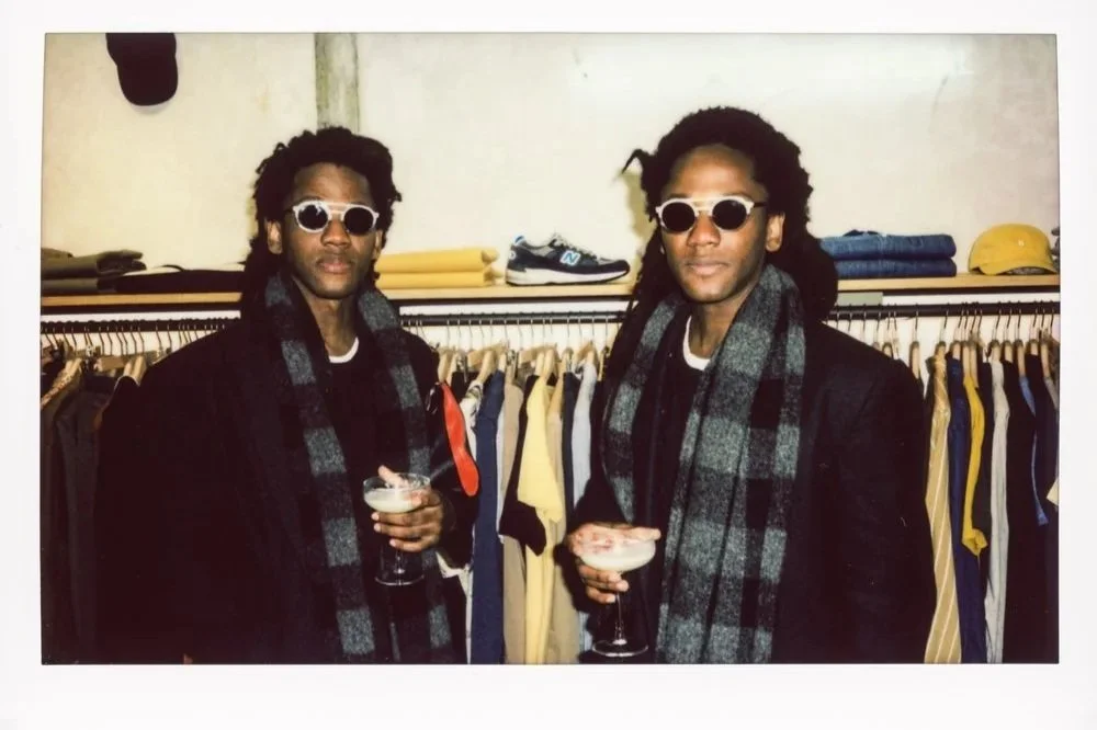 Polaroid-style photo of two guests holding drinks and posing at a fashion event