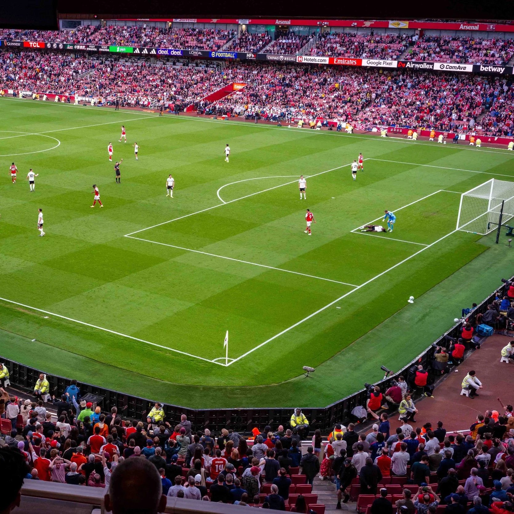 Elevated view of Arsenal players on the pitch and packed stands during a match at Emirates Stadium, London.
