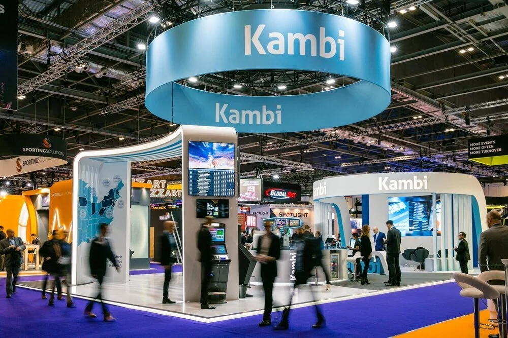 Large branded exhibition stand at a trade show with delegates walking through the exhibition hall.