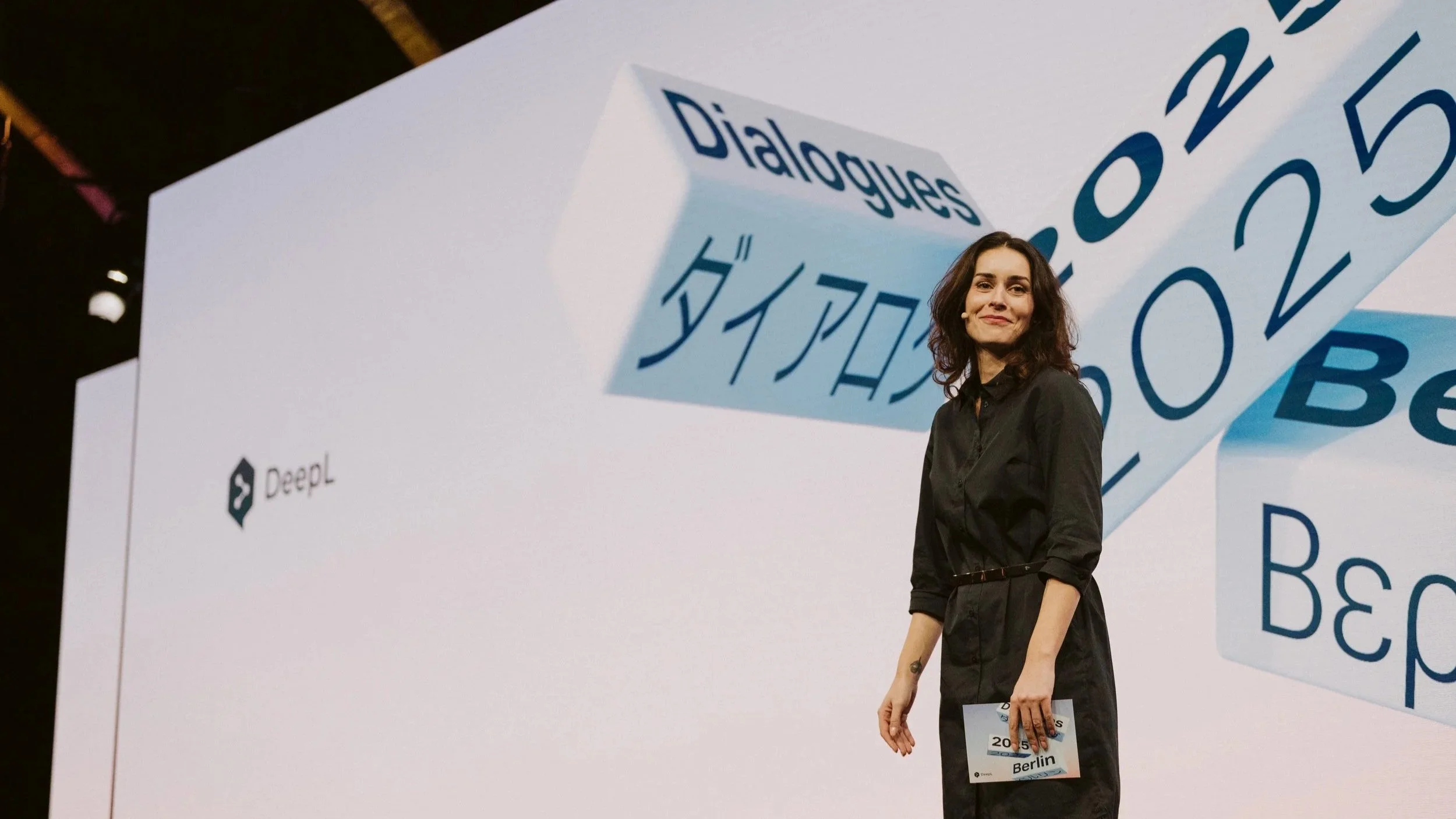 Conference host on stage at DeepL Dialogues 2025 in Berlin, photographed for Smyle