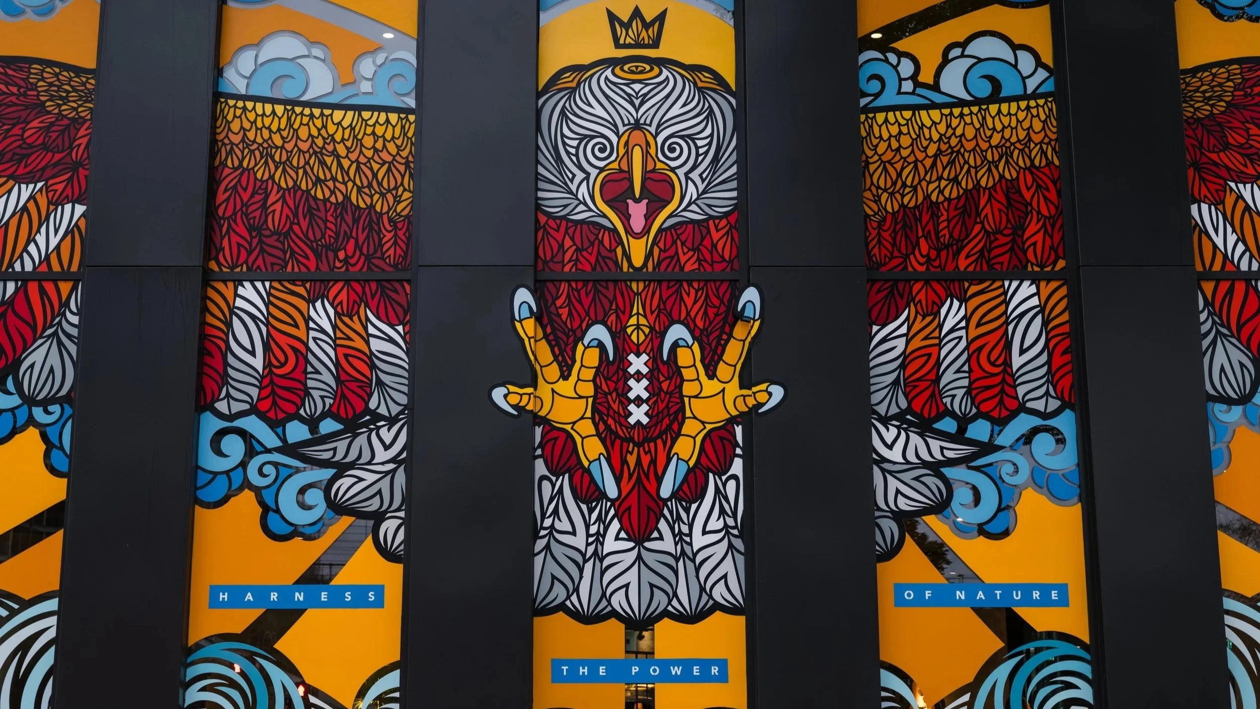 Colourful eagle mural across window panels at Ruby Hotels in Amsterdam
