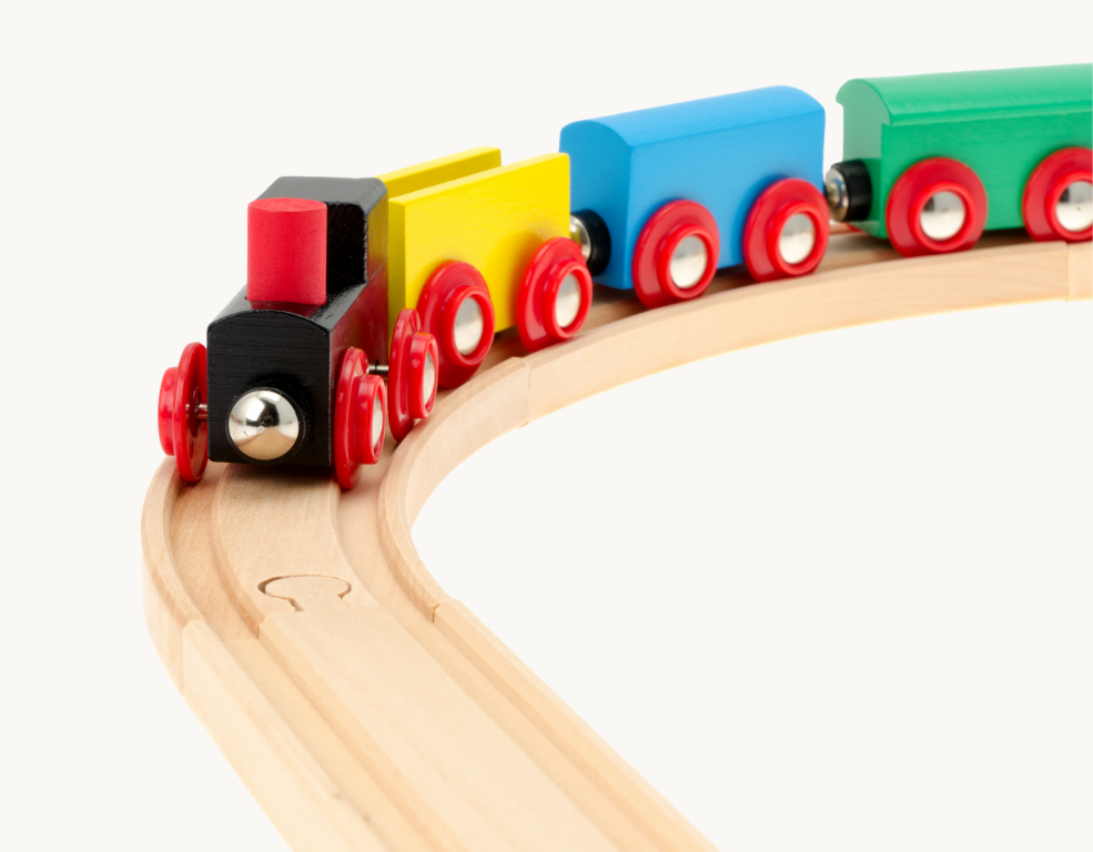 Colorful wooden toy train with red wheels on a curved wooden track.