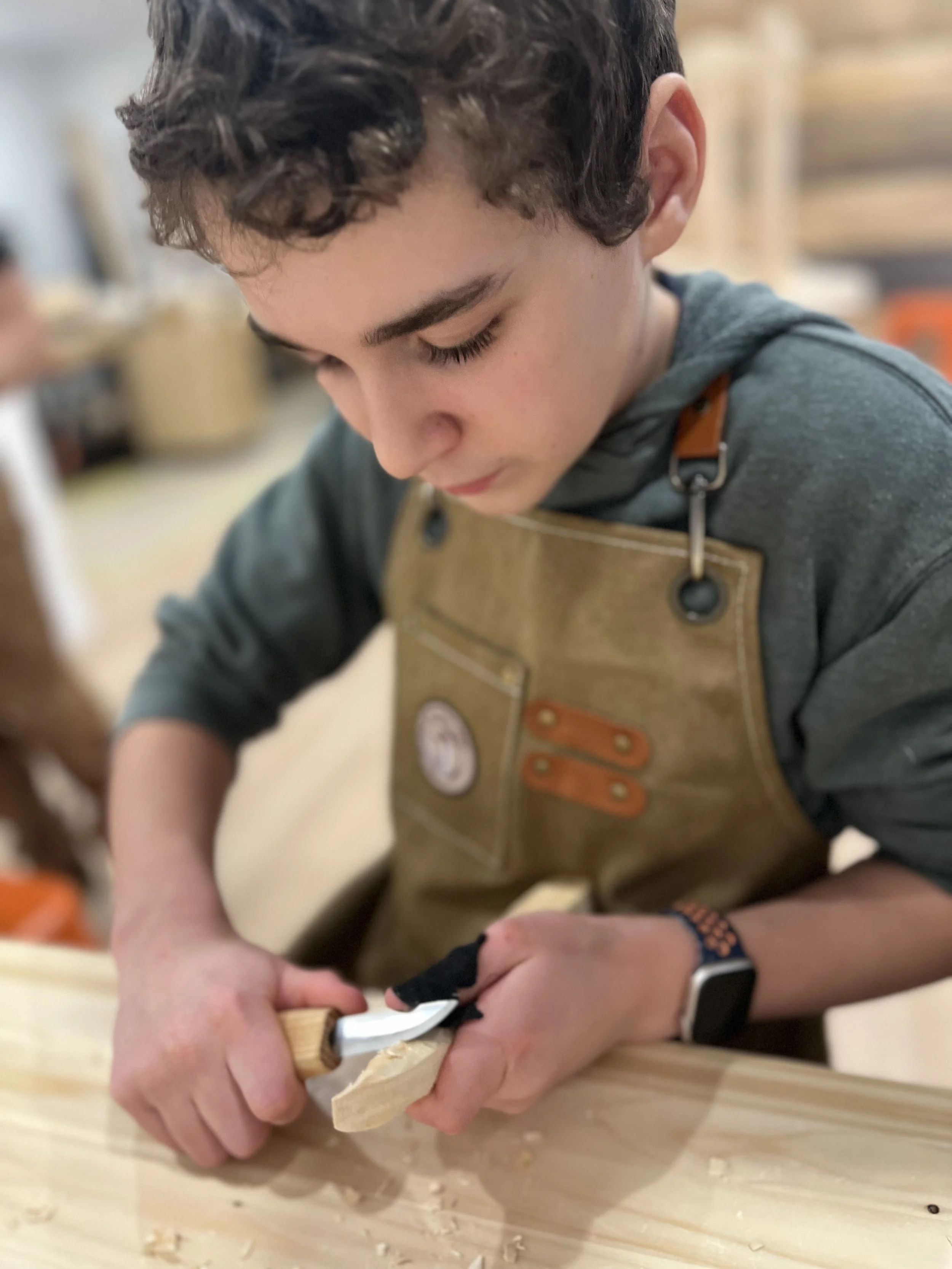 Wall with woodworking tools including saws, chisels, screwdrivers, and clamps organized on wooden and metal racks.