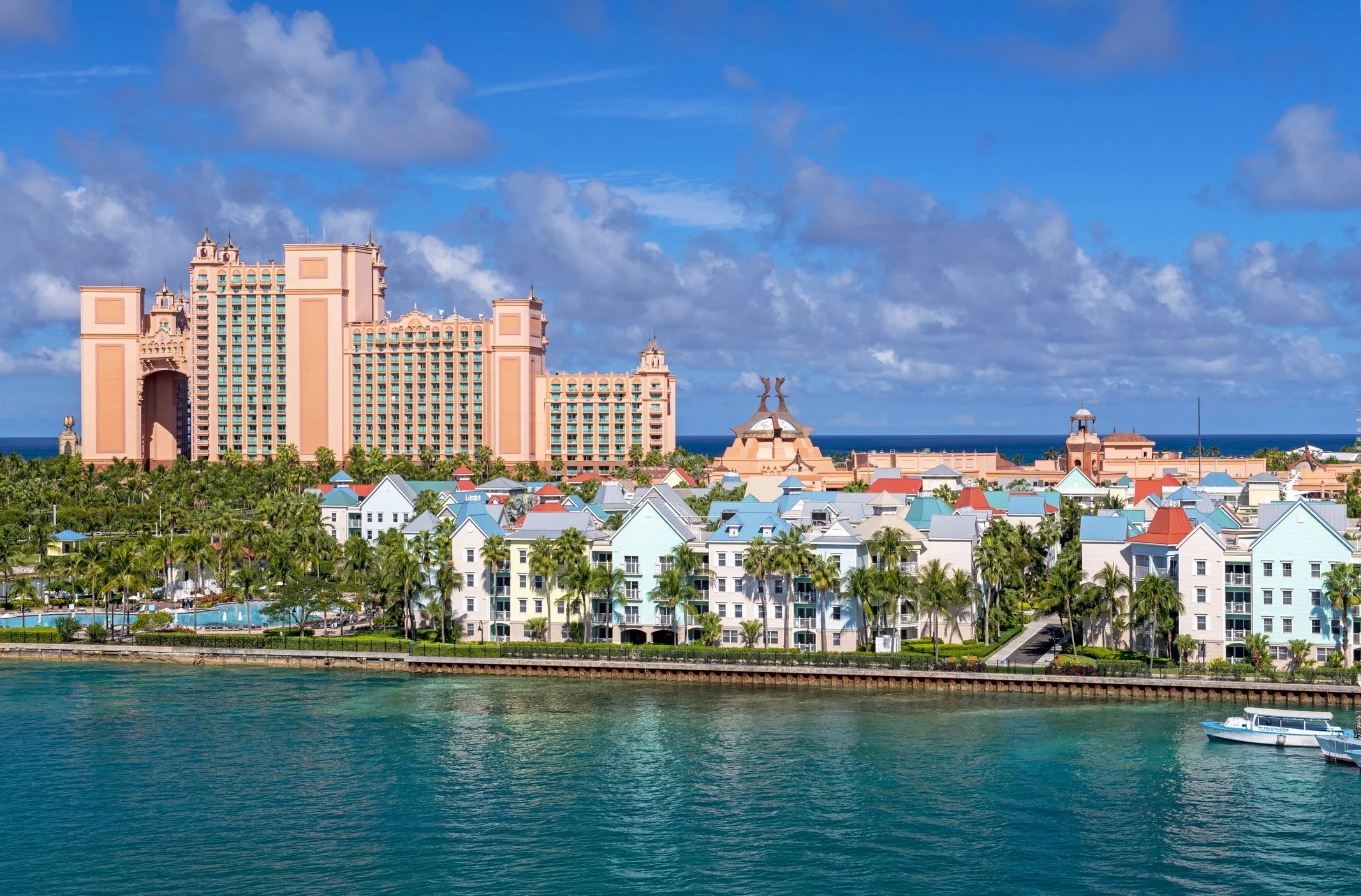 Drone view of Paradise Island Bahamas towers and pastel condos against a blue sky and aqua water
